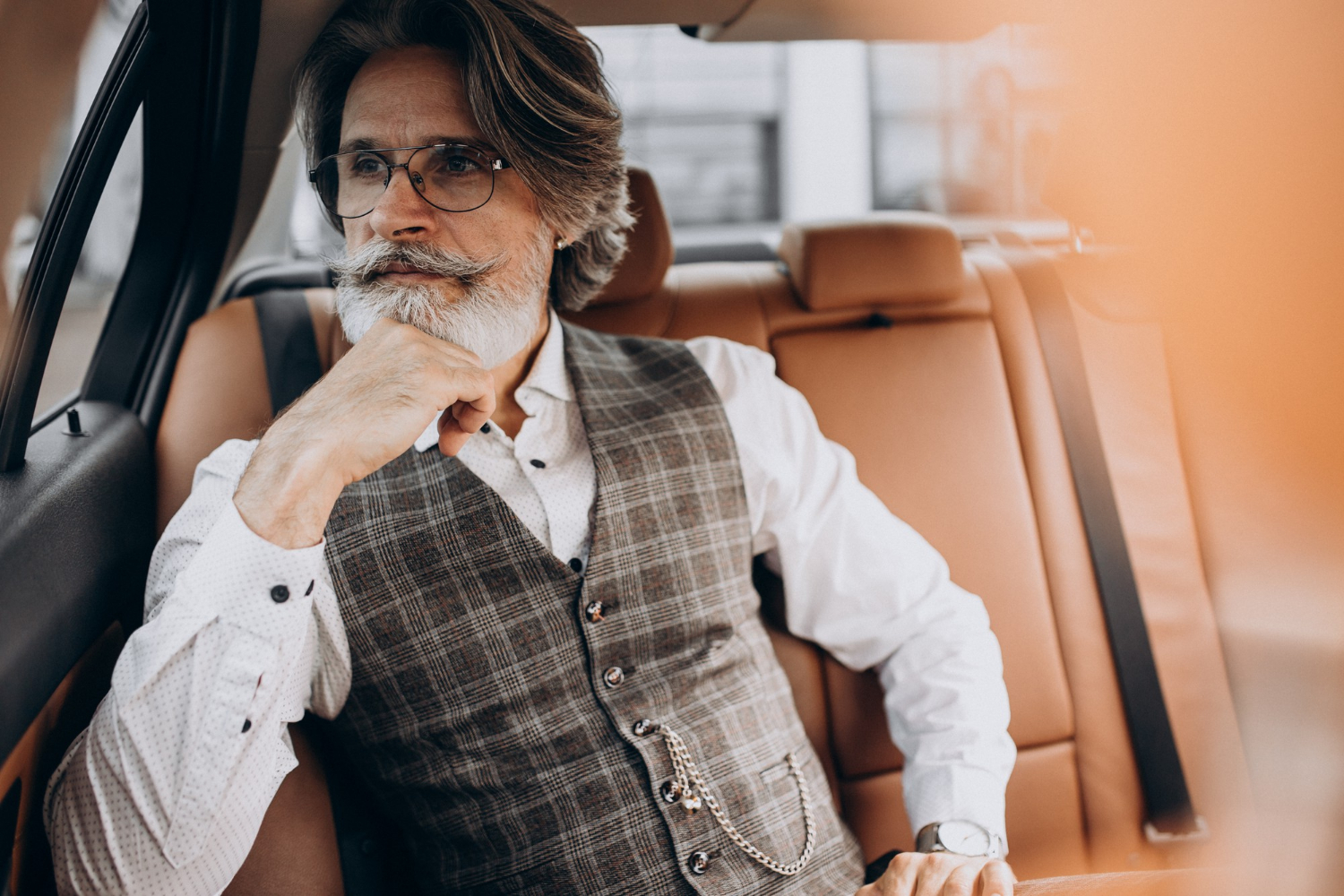 Un elegante hombre mayor sentado en su automóvil | Fuente: Freepik