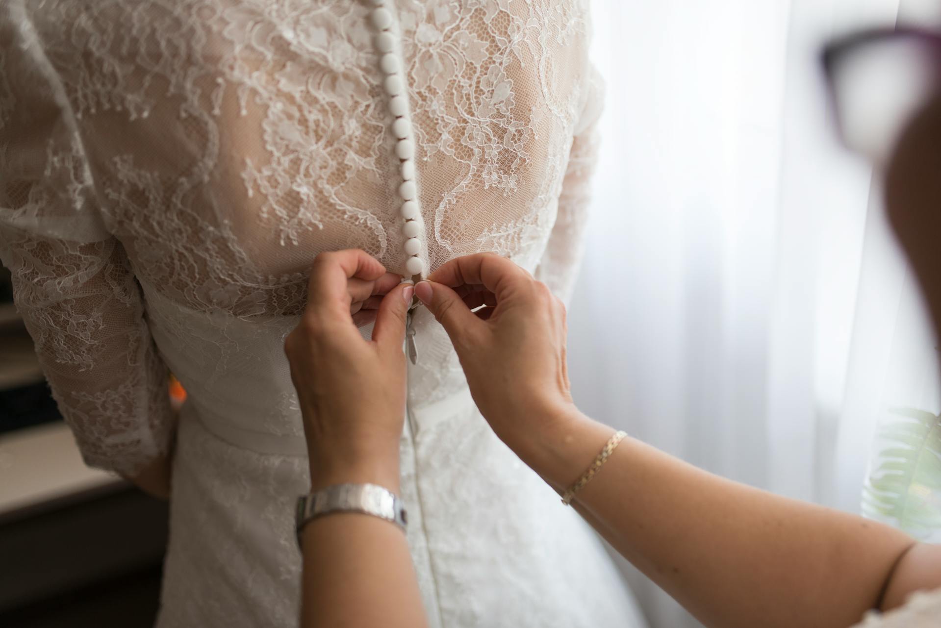 Una mujer ayuda a una novia con su vestido | Fuente: Pexels