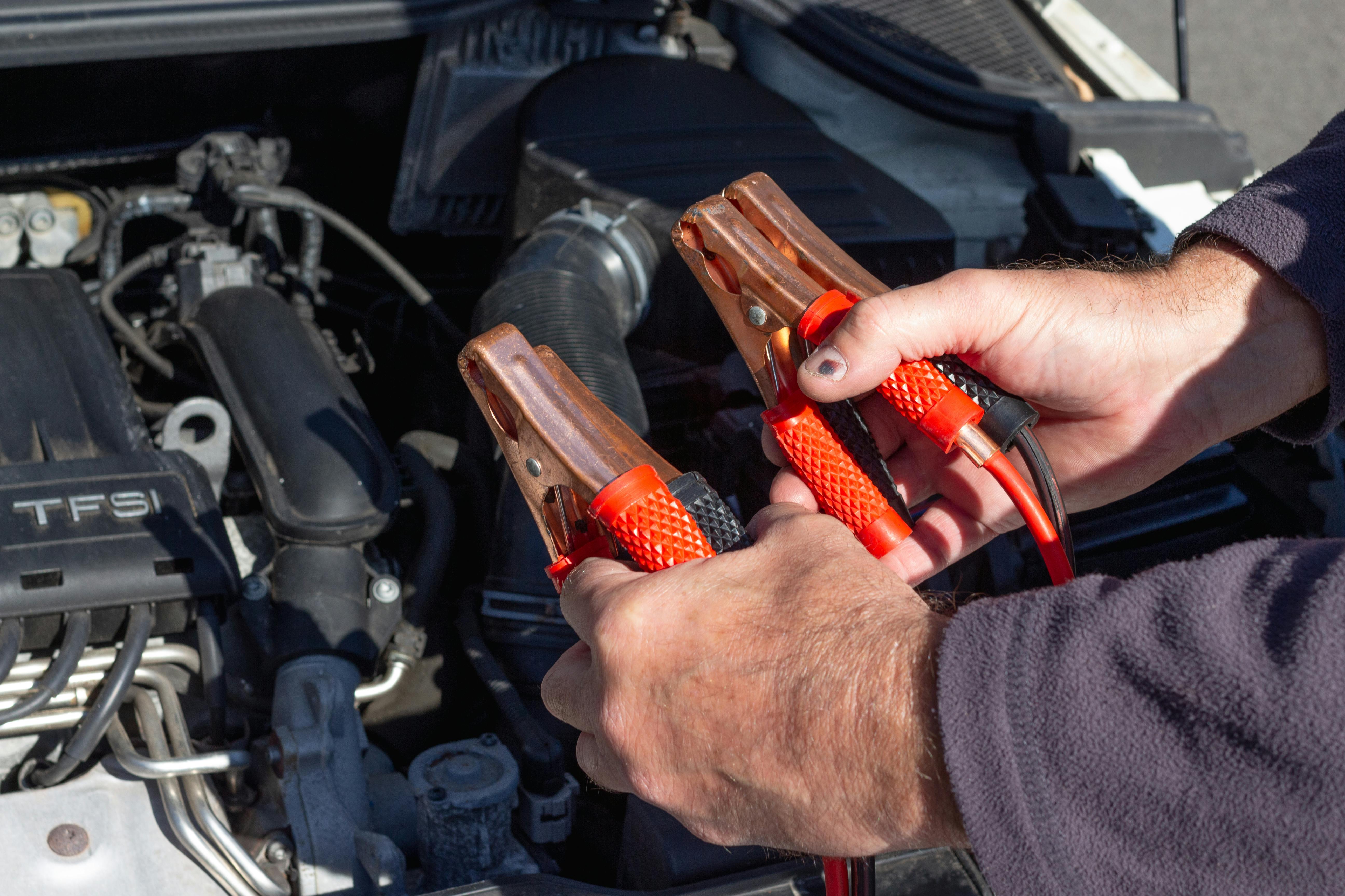 Un hombre sujetando cables de arranque | Fuente: Pexels