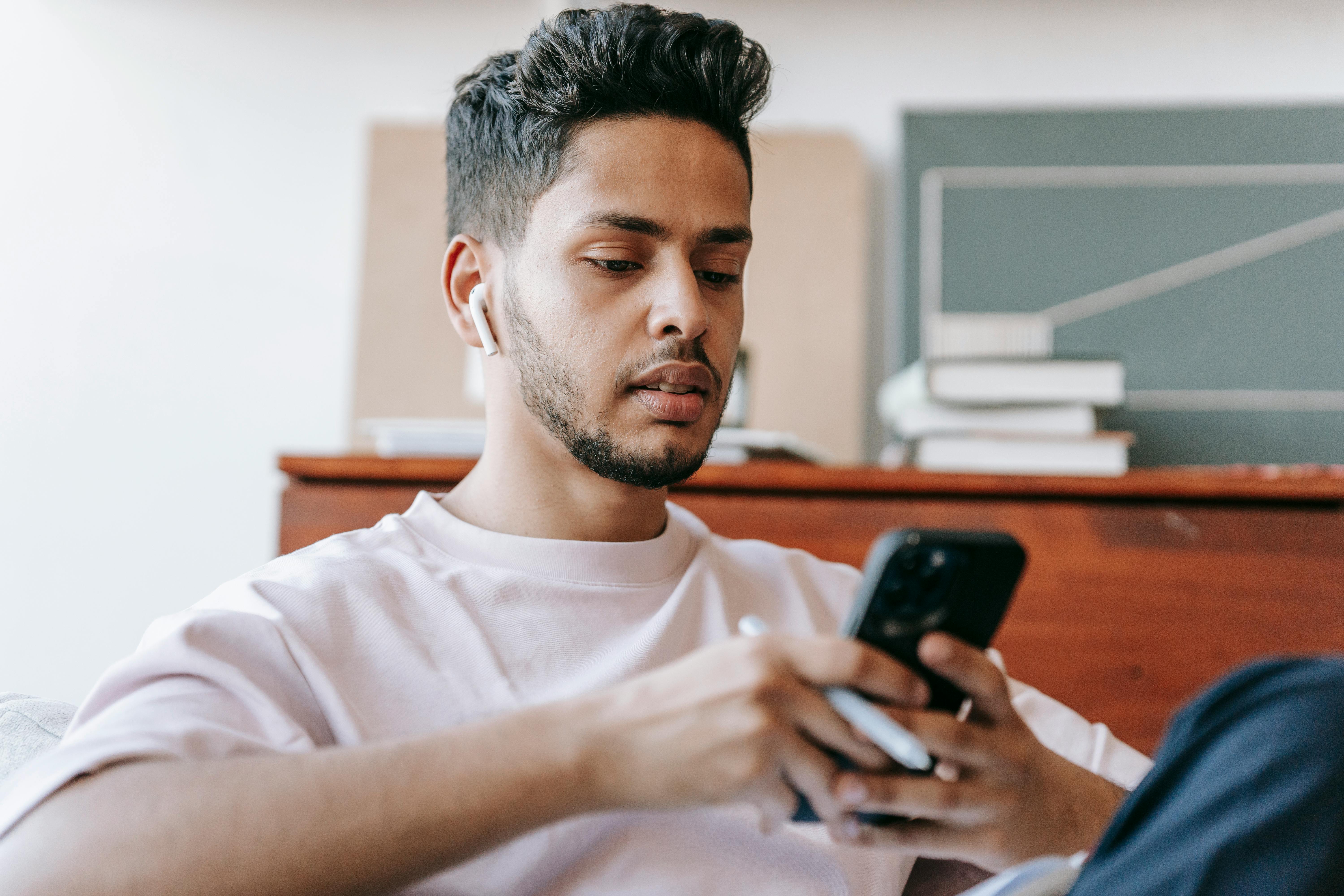 Un joven utilizando su smartphone | Fuente: Pexels
