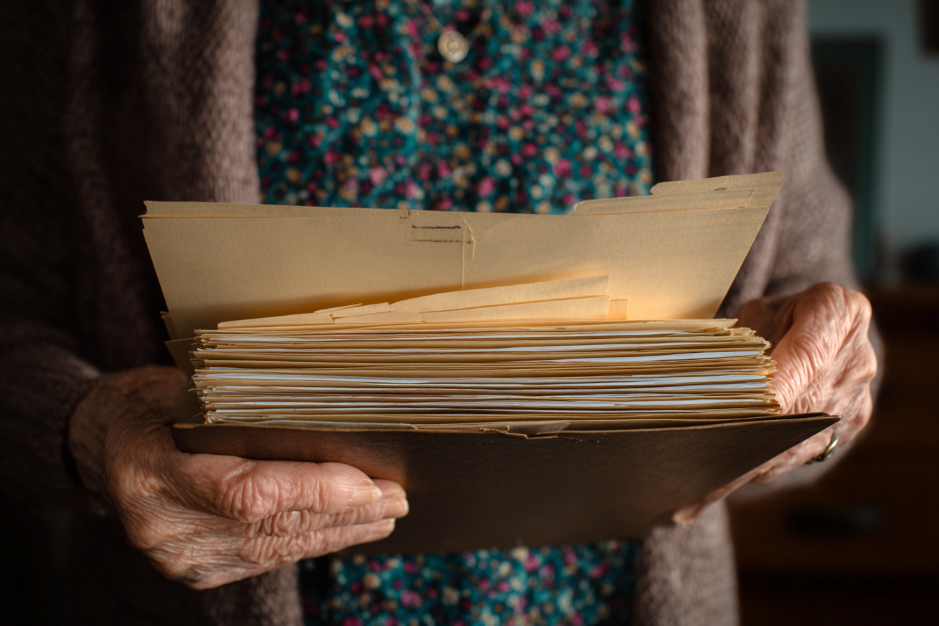 Una mujer mayor con una carpeta en la mano | Fuente: Midjourney