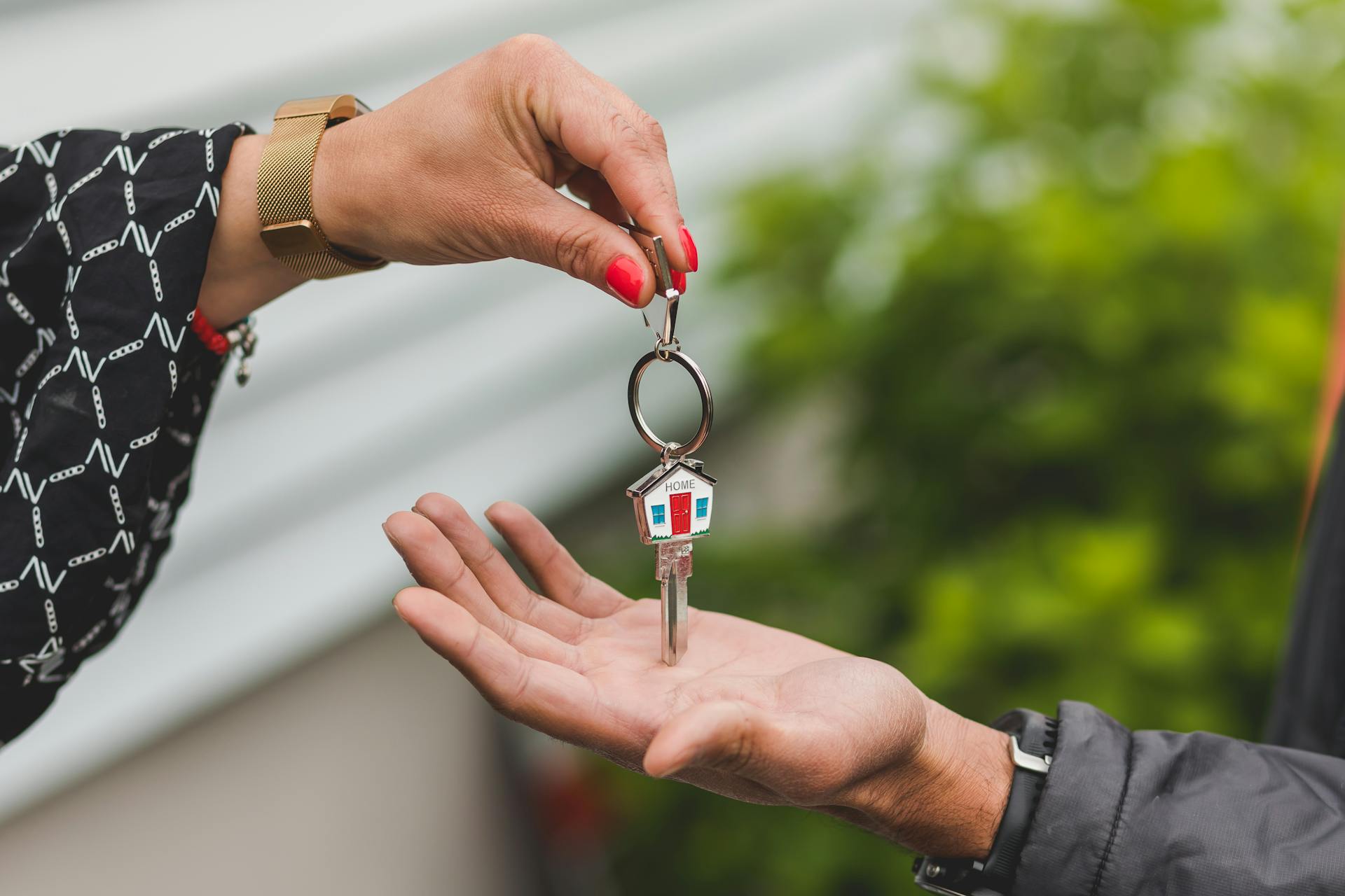 Una mujer entrega las llaves de casa a un hombre | Fuente: Pexels