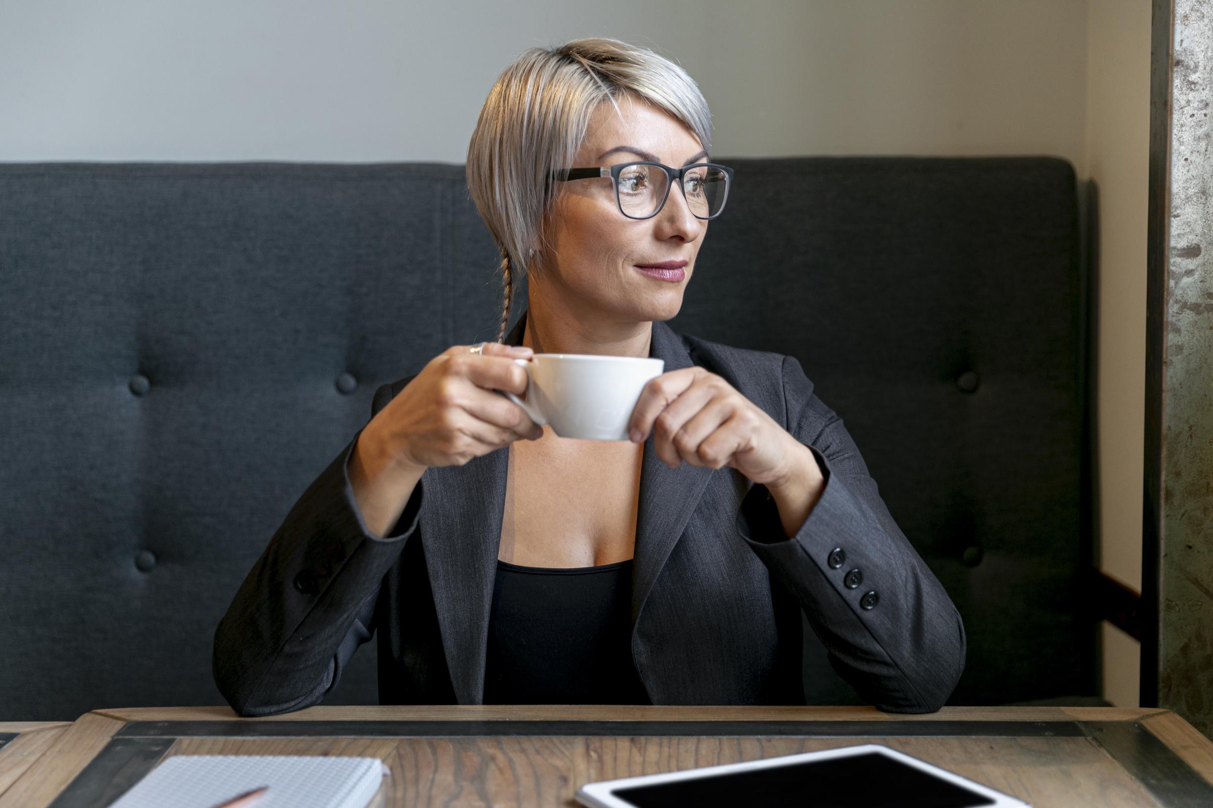 Una mujer alegre con una taza de café en la mano | Fuente: Freepik