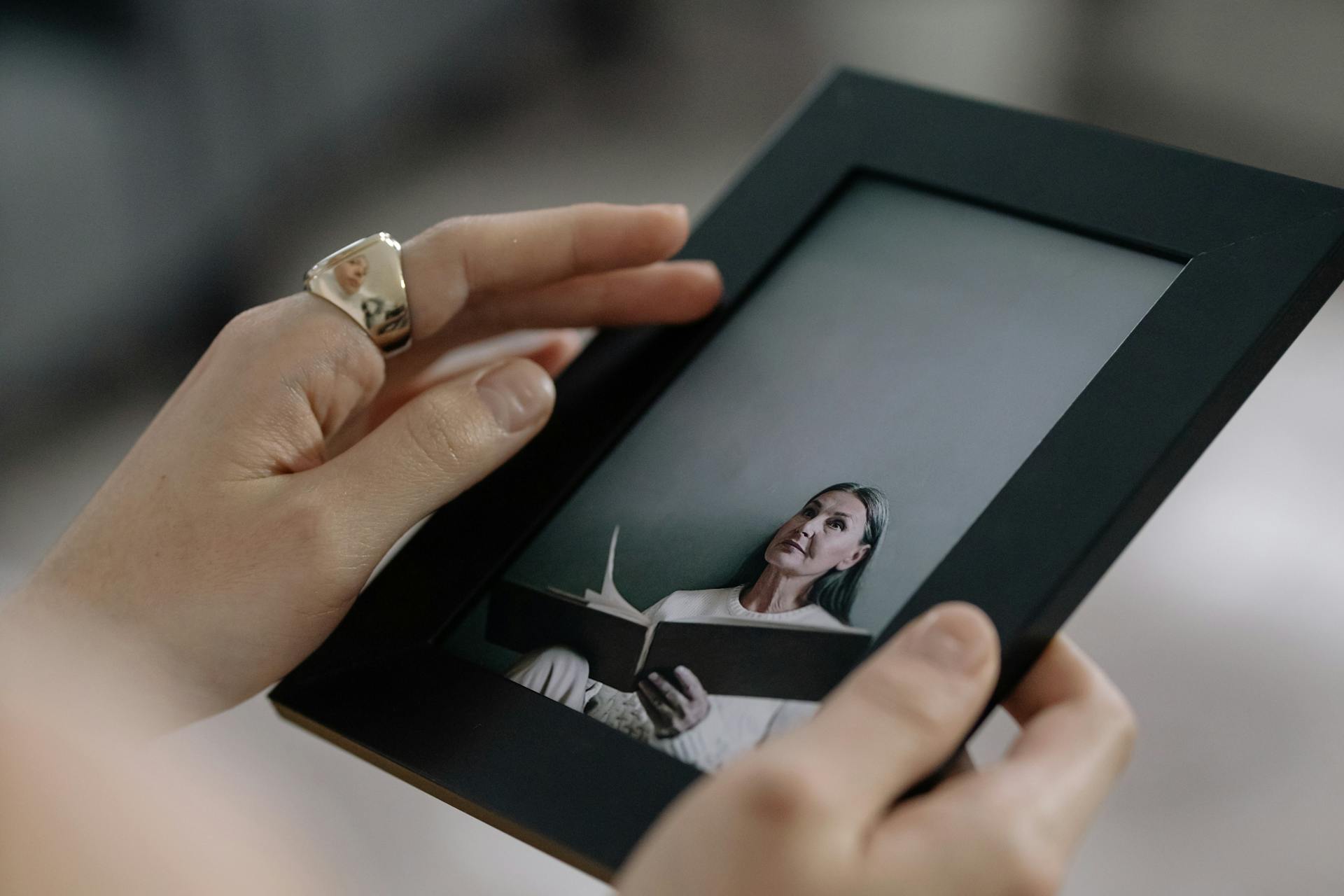Una persona sujetando un marco de fotos negro | Fuente: Pexels