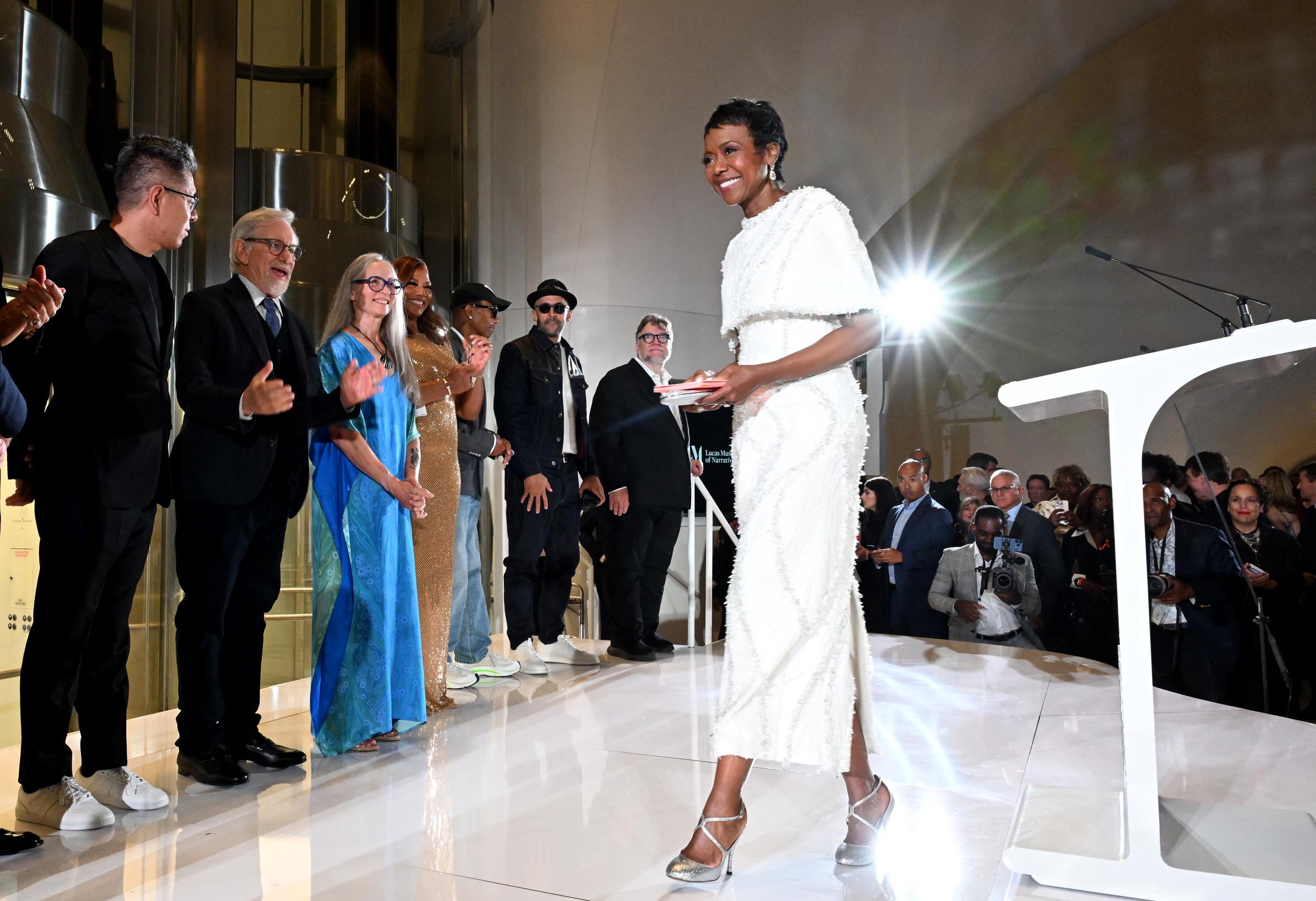 Mellody Hobson salió al escenario durante el programa de la noche de inauguración mientras los invitados la aplaudían a sus espaldas. Entre los que se encontraban cerca estaban Ma Yansong, Steven Spielberg, Julie Bell, Queen Latifah, Pharrell Williams, JR y Guillermo del Toro. | Fuente: Getty Images