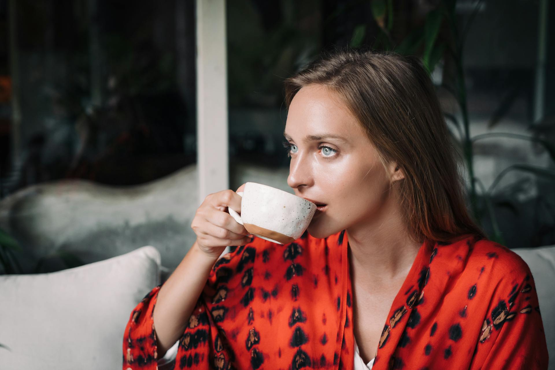 Una mujer bebiendo té mirando fijamente a alguien | Fuente: Pexels