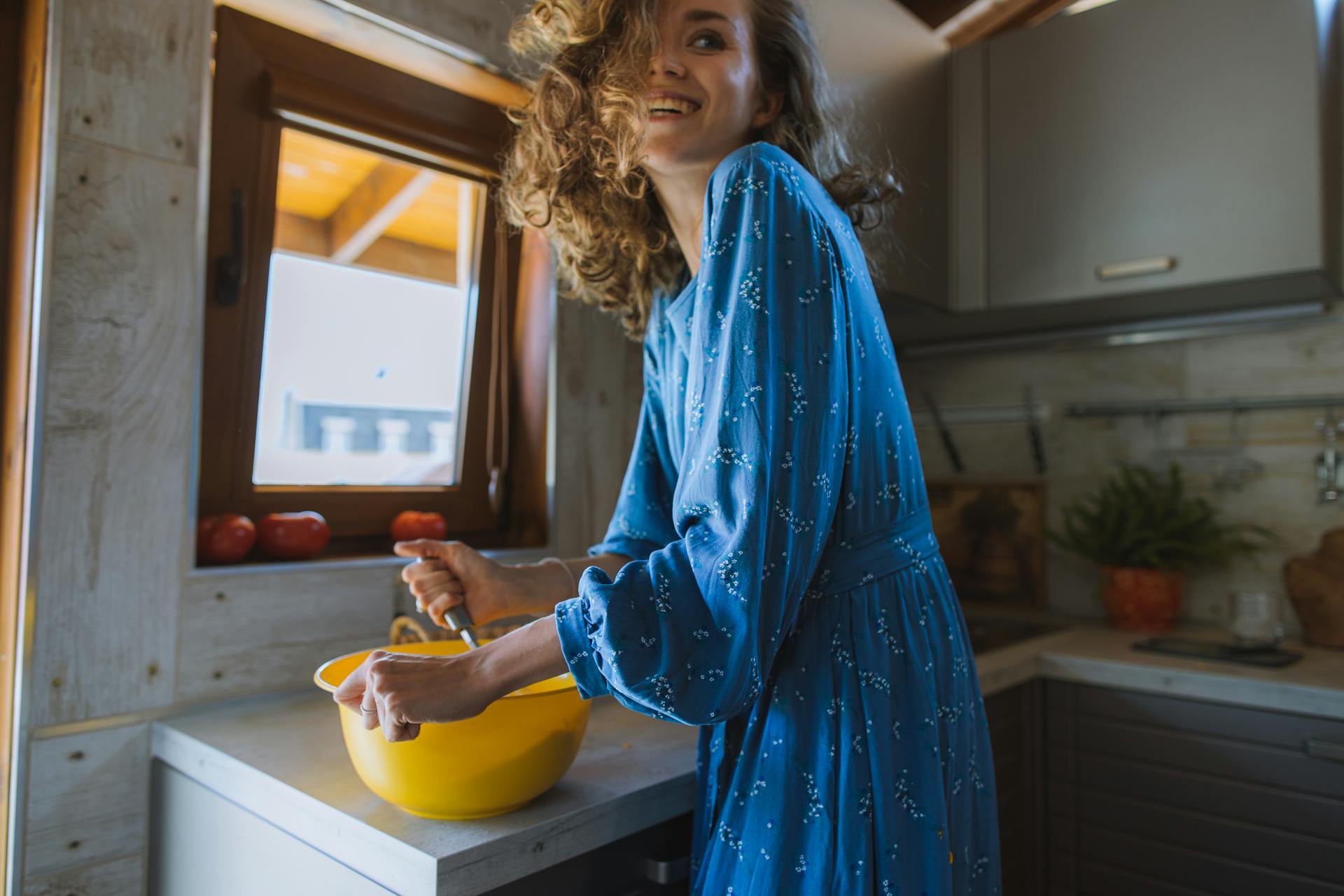 Una mujer sonriente cocinando | Fuente: Pexels