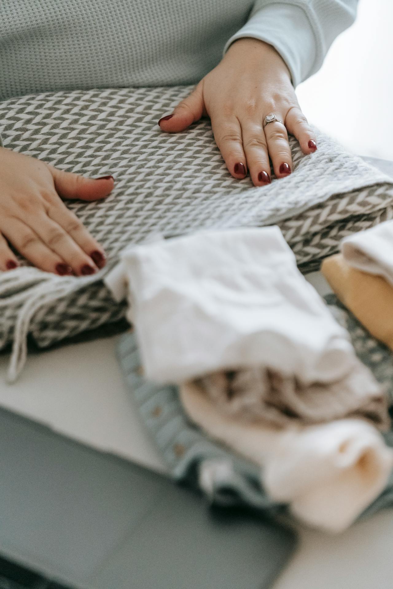 Una mujer doblando la ropa | Fuente: Pexels