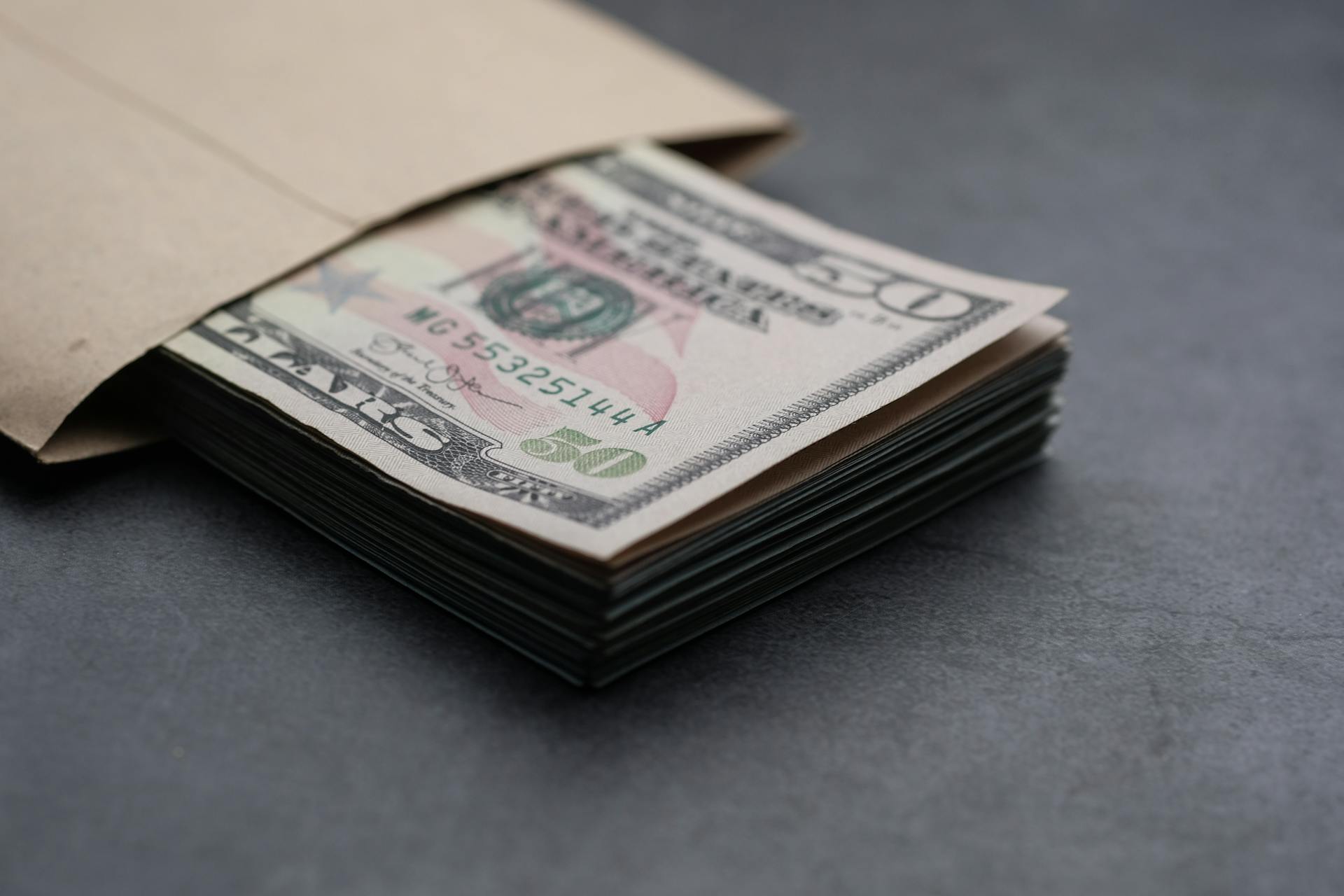 Un montón de billetes de dólar en un sobre | Fuente: Pexels