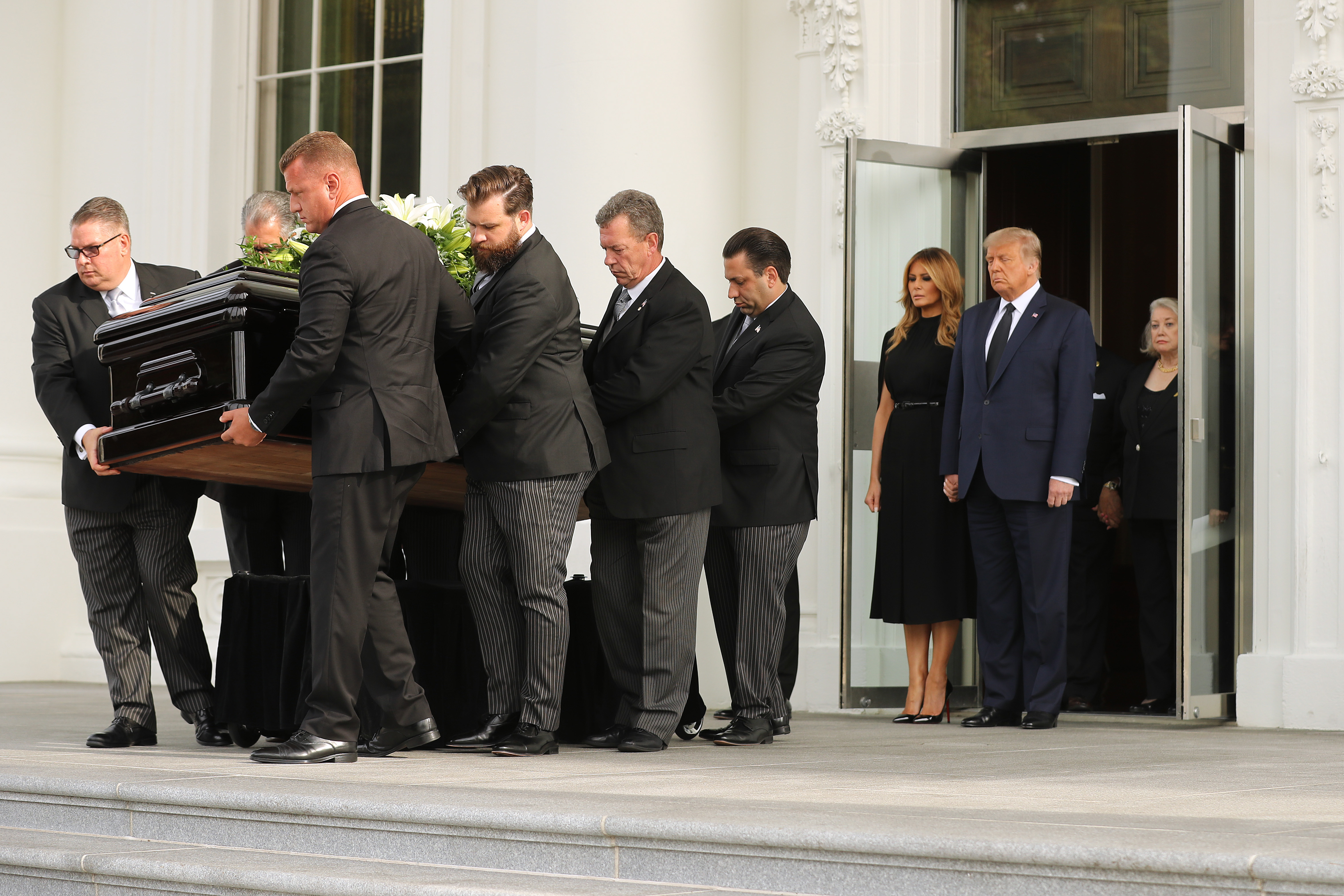 El presidente Donald Trump y la primera dama Melania Trump siguen el féretro de Robert Trump fuera de la Casa Blanca tras su funeral el 21 de agosto de 2020 | Fuente: Getty Images