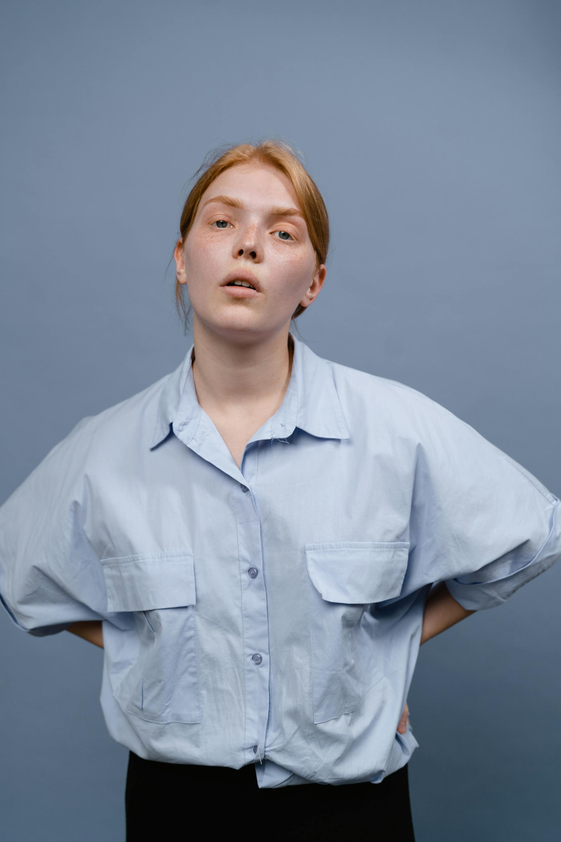 Una mujer con las manos en las caderas y expresión cansada | Fuente: Pexels