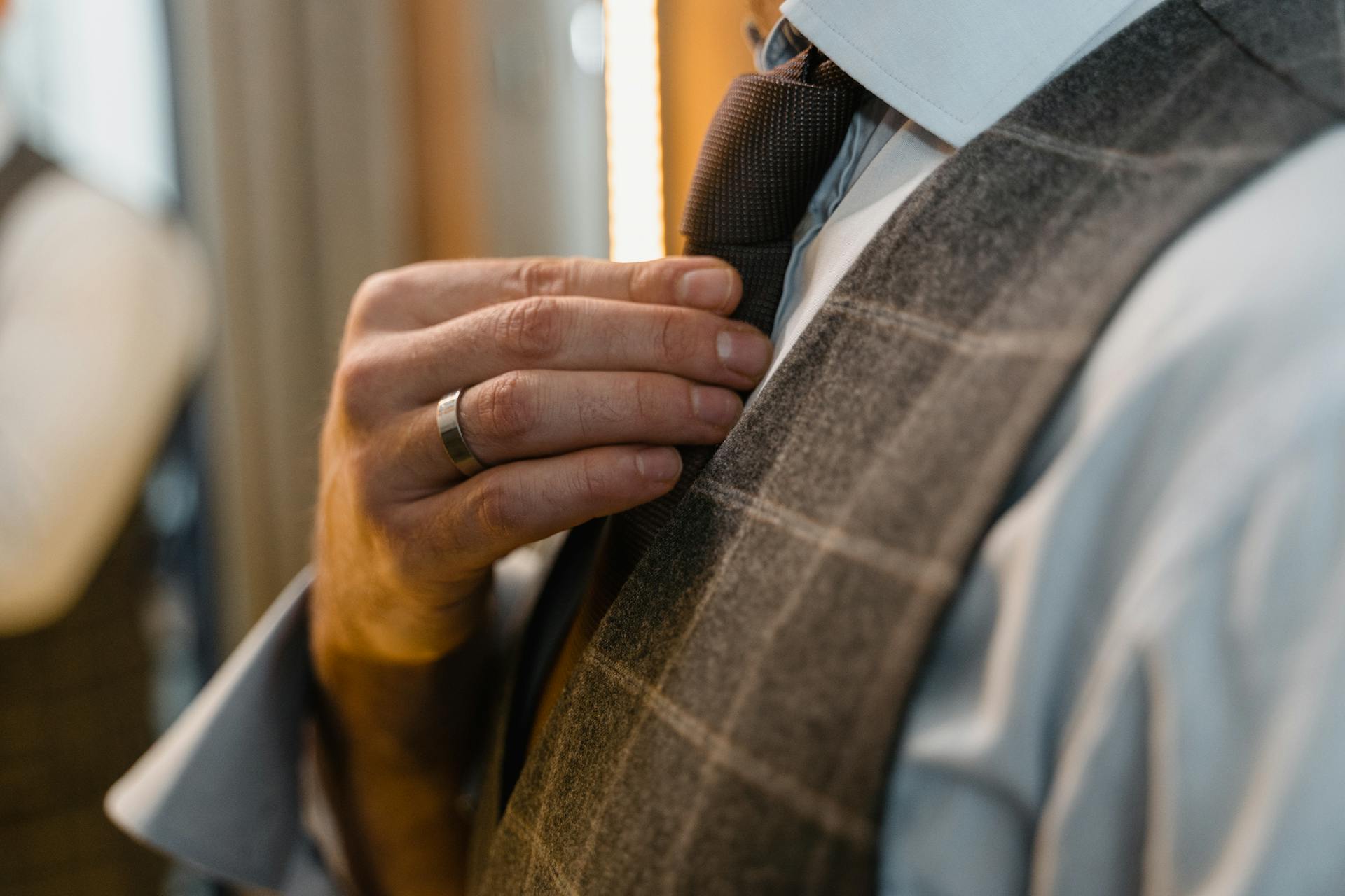 Un hombre ajustándose la corbata | Fuente: Pexels
