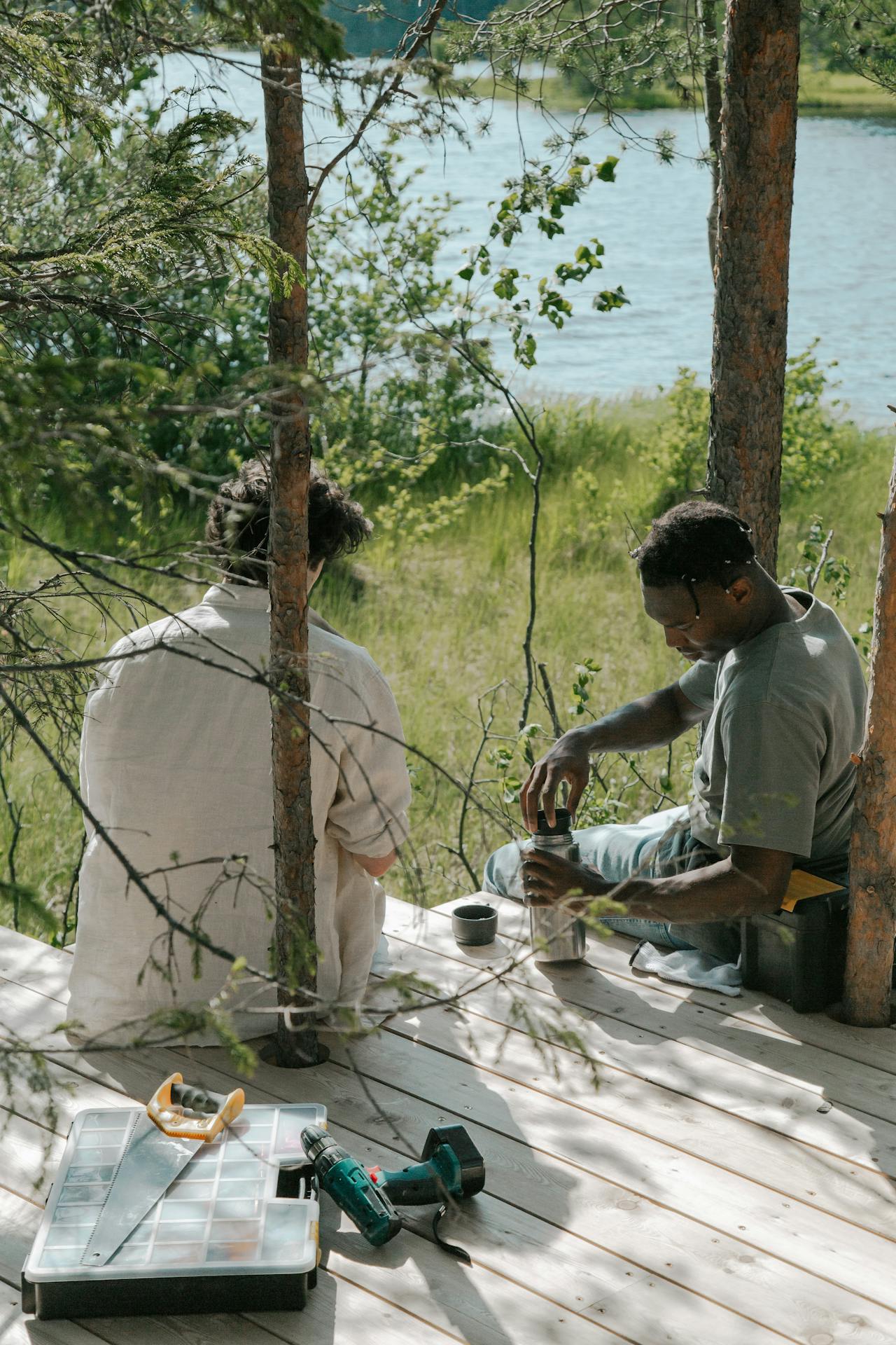 Dos hombres sentados en tablas de madera | Fuente: Pexels