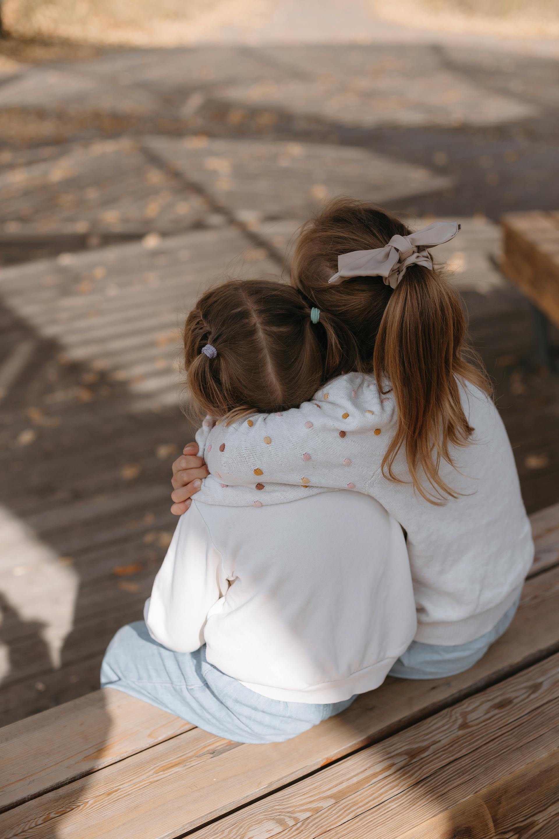 Dos chicas sentadas y abrazadas | Fuente: Pexels