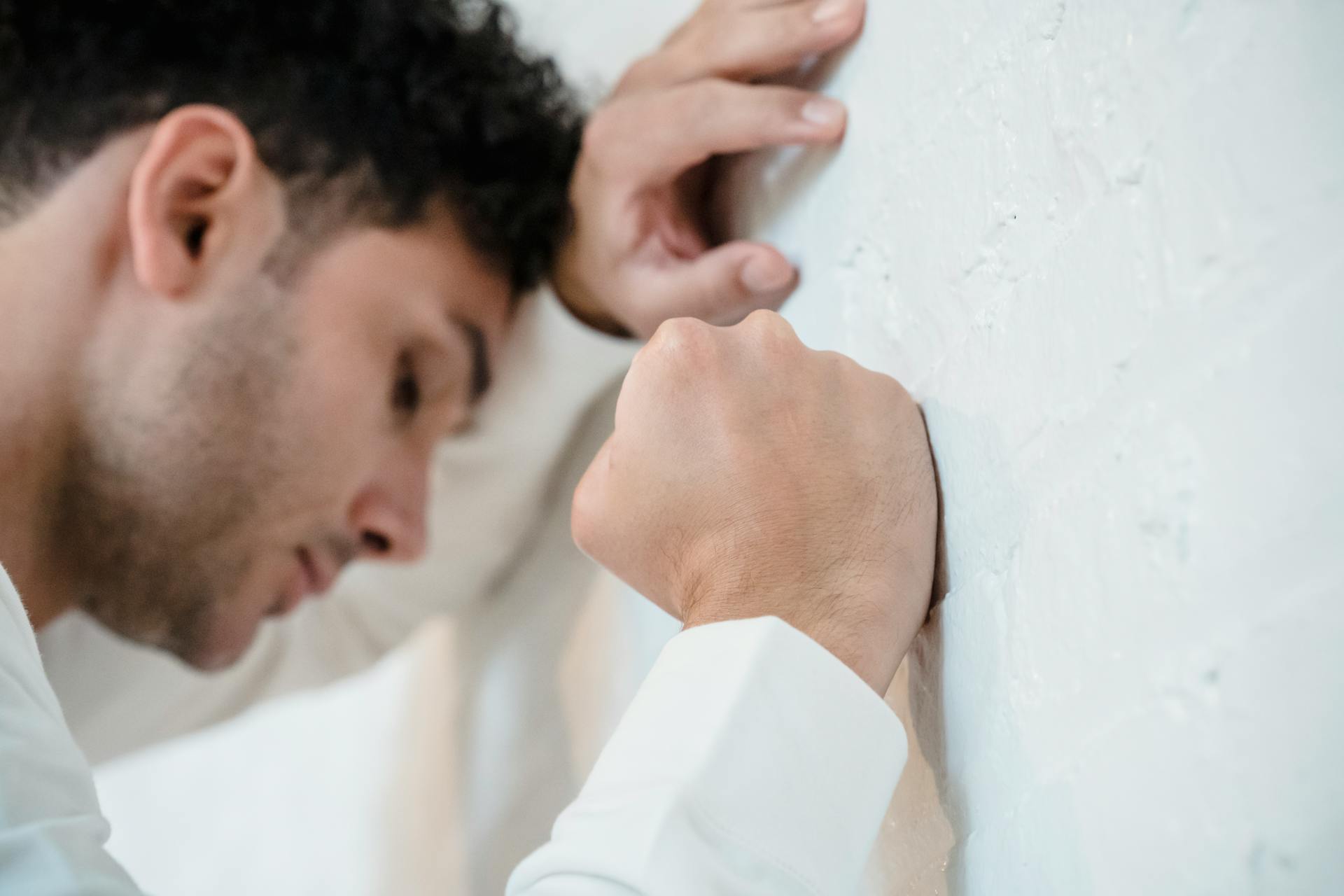 Un hombre frustrado apoyado en la pared | Fuente: Pexels