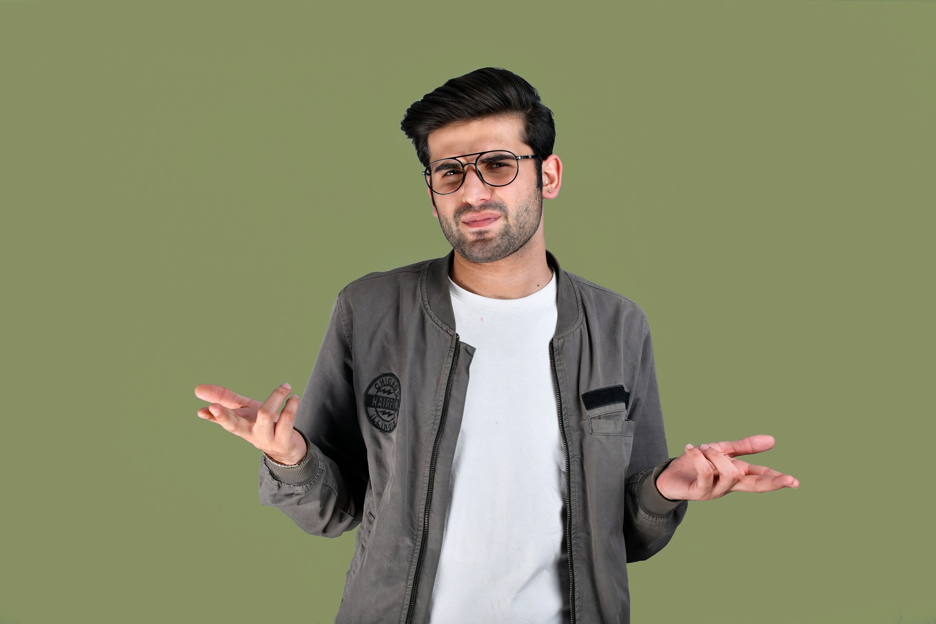 Un hombre ceñudo encogiéndose de hombros mientras habla | Fuente: Unsplash