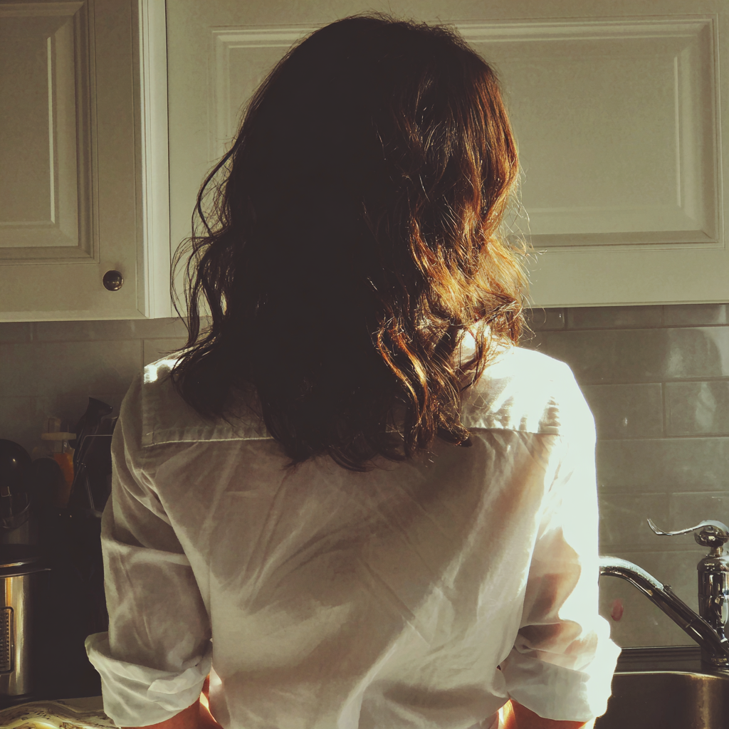 Una mujer ante un fregadero de cocina | Fuente: Midjourney