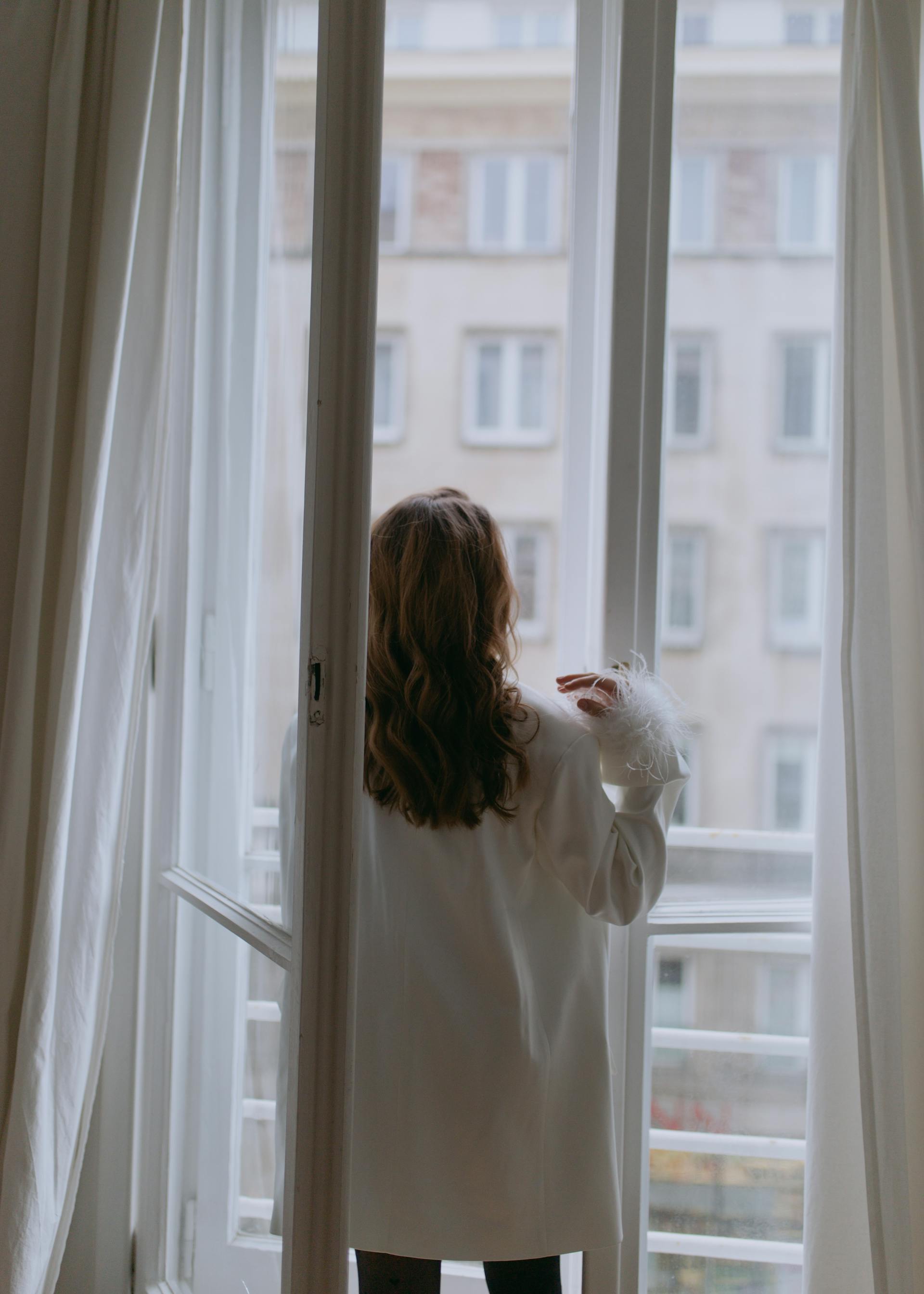 Una mujer junto a una ventana abierta | Fuente: Pexels