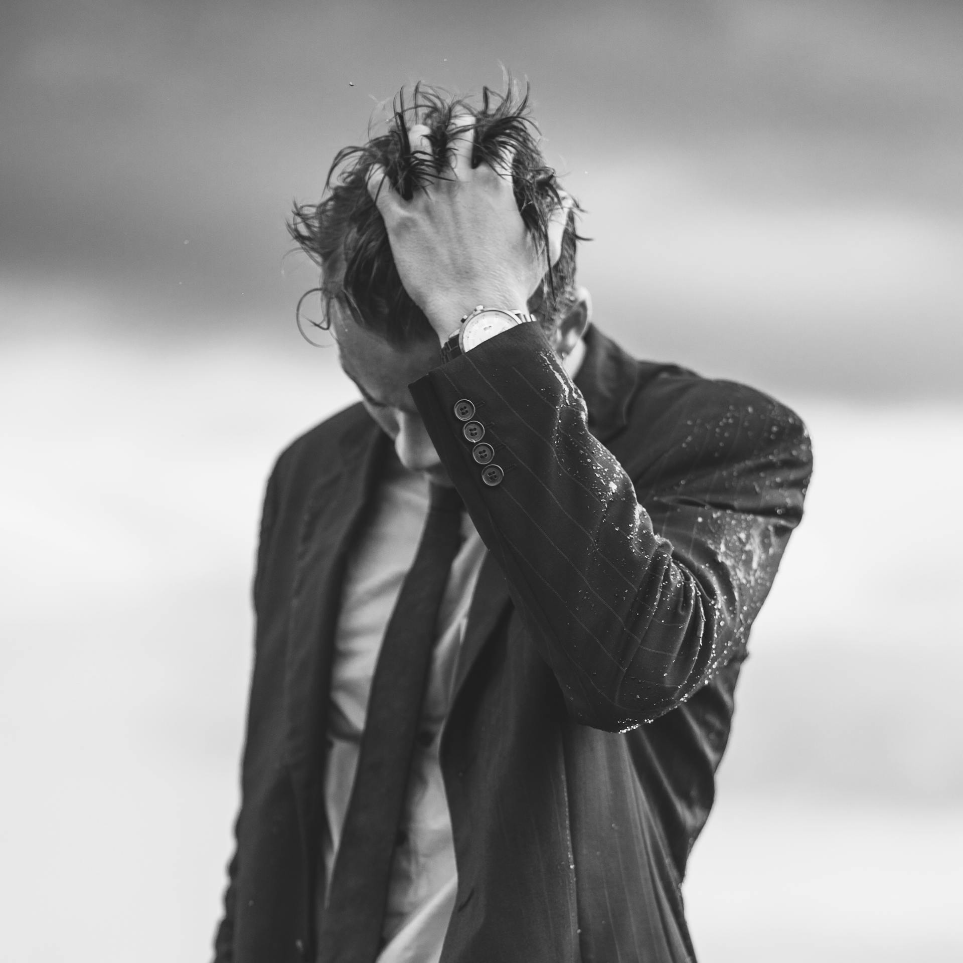 Un hombre trajeado con las manos en el pelo | Fuente: Pexels