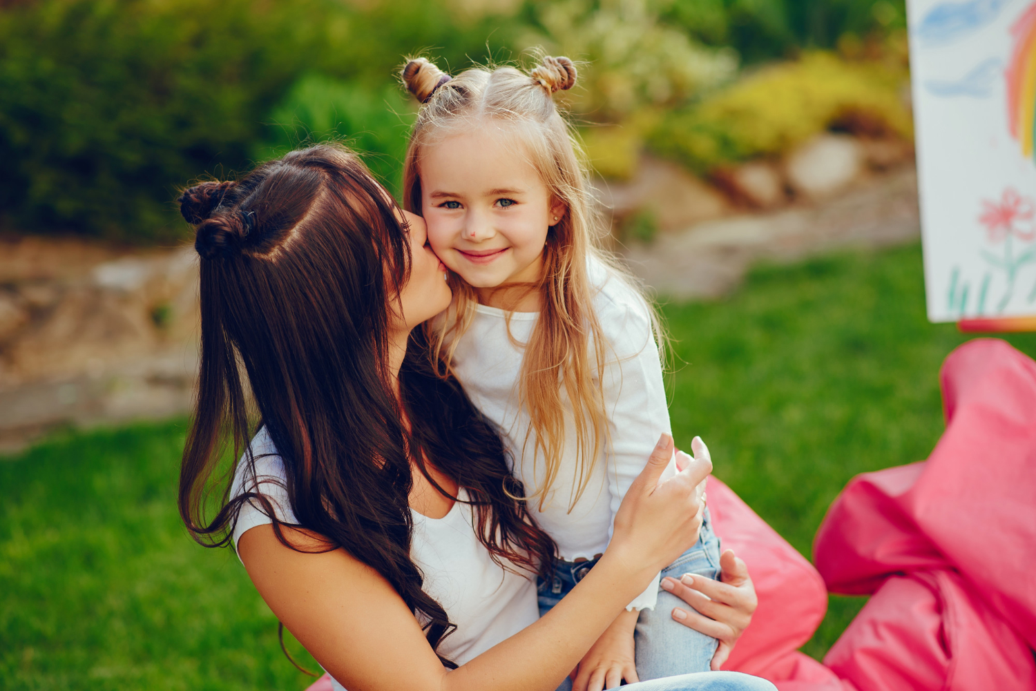 Una mujer besa a su hija en la mejilla | Fuente: Freepik