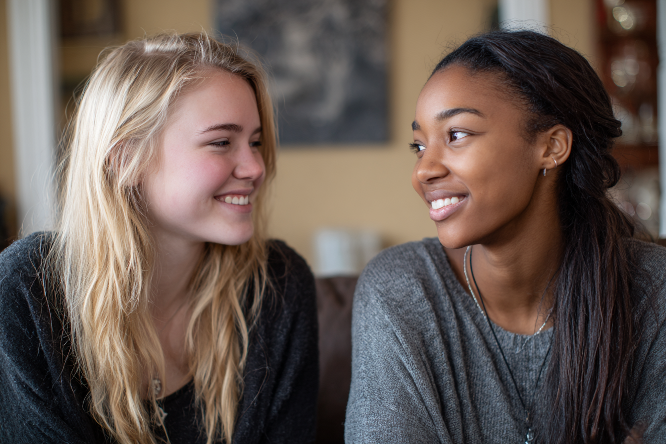Dos chicas adolescentes sonriéndose | Fuente: Midjourney
