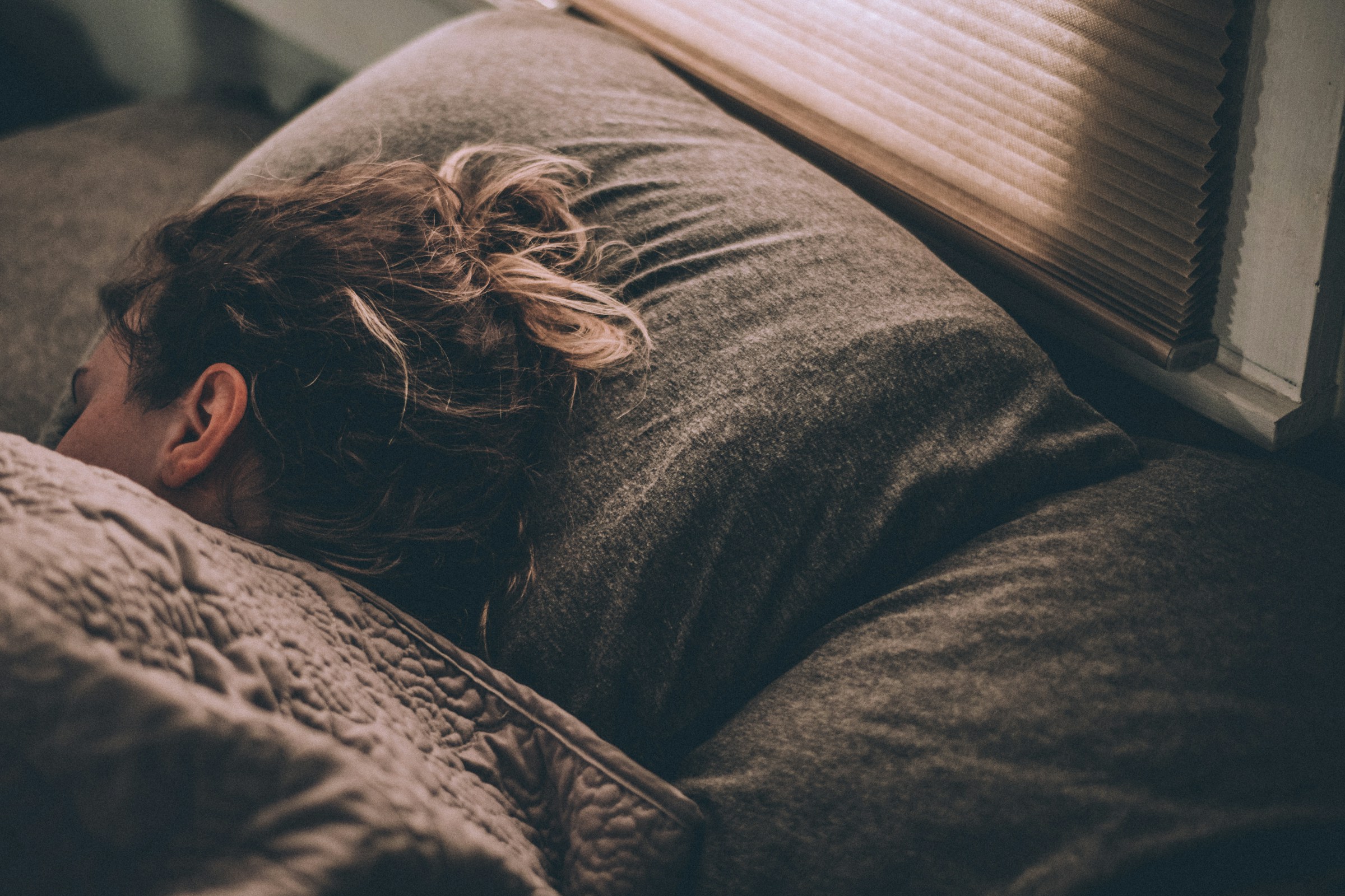 Una mujer profundamente dormida en su habitación | Fuente: Unsplash