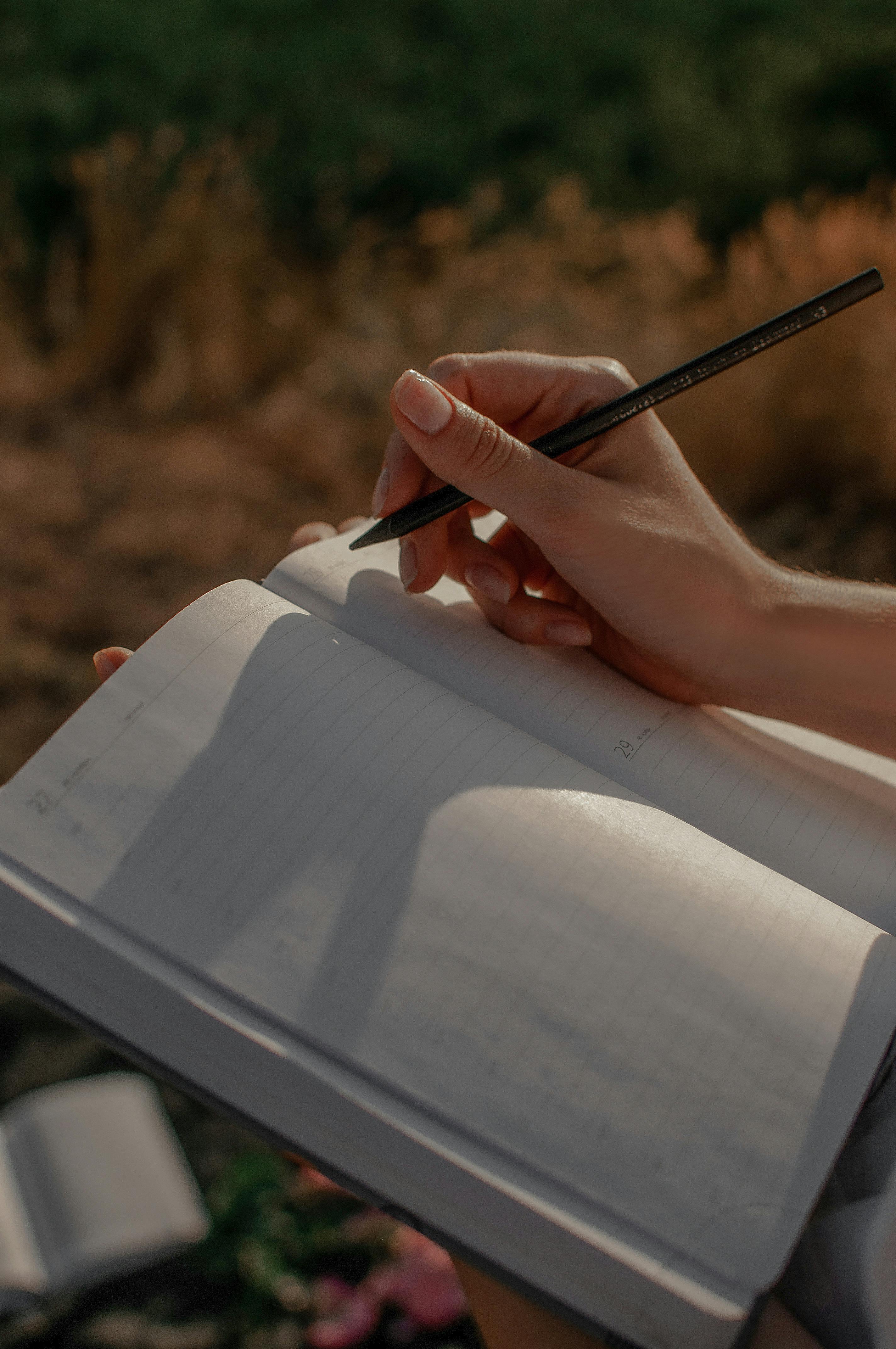 Una mujer escribiendo en un diario | Fuente: Pexels