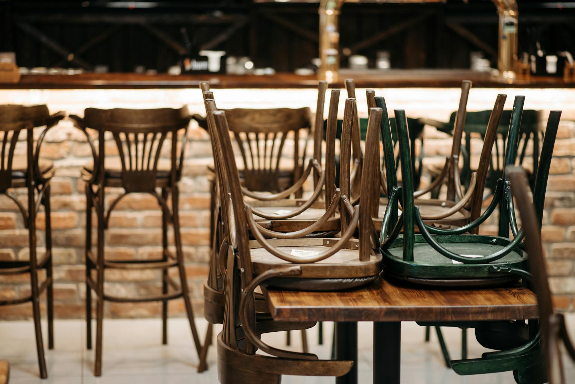 Sillas de madera apiladas sobre una mesa | Fuente: Pexels