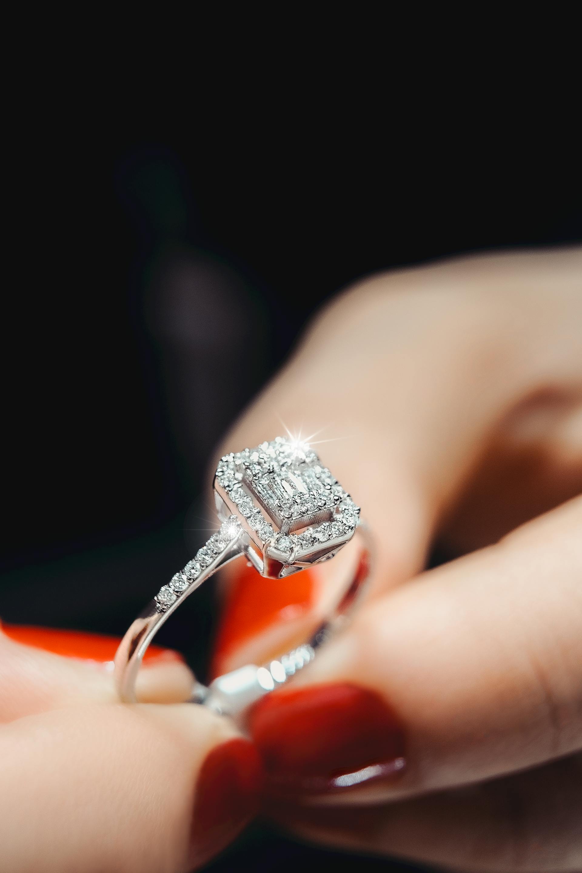 Primer plano de las manos de una mujer sujetando un anillo de diamantes | Fuente: Pexels