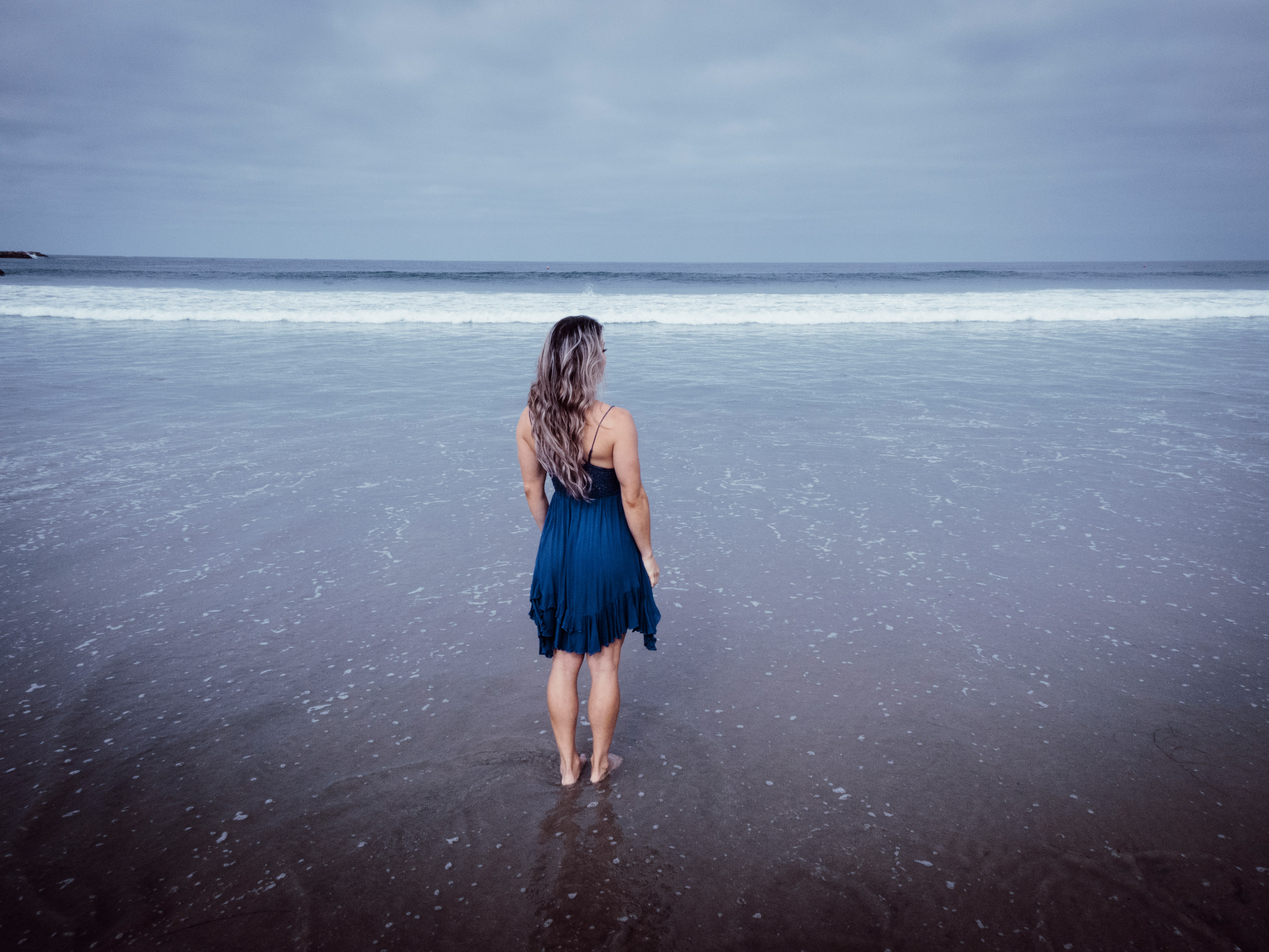 Una mujer de pie en una playa | Fuente: Unsplash