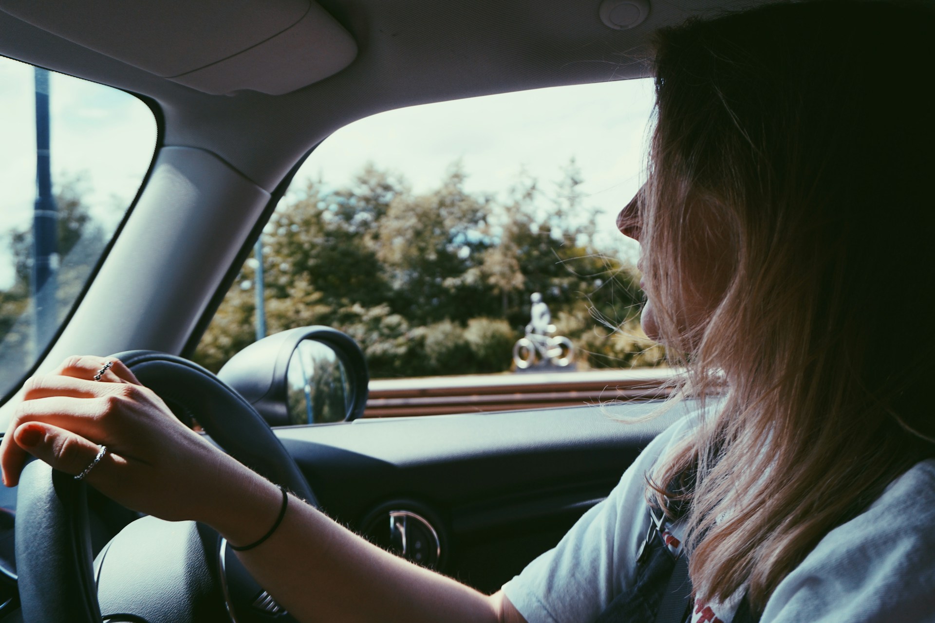 Una mujer alegre conduciendo un automóvil | Fuente: Unsplash
