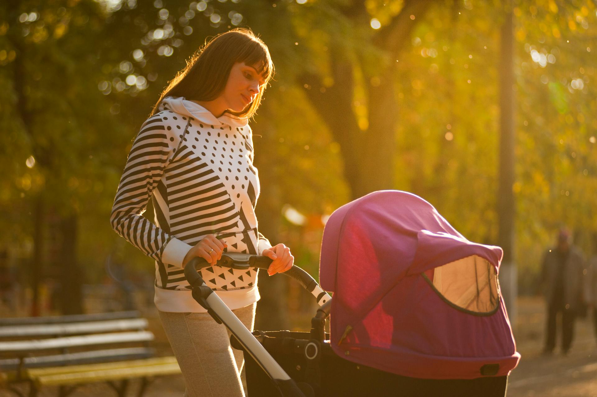 Una mujer sujetando un cochecito de bebé | Fuente: Pexels