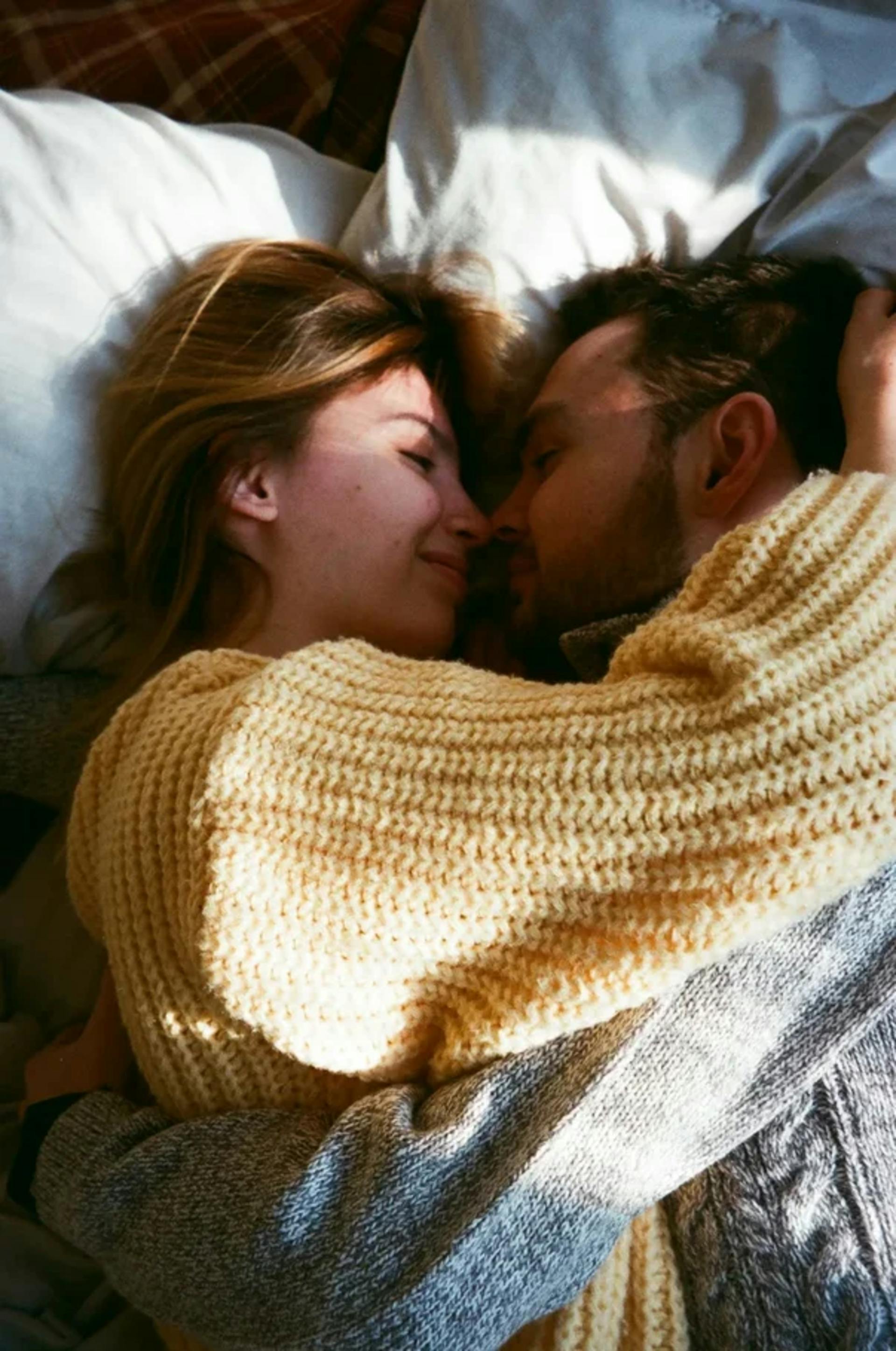 Una pareja feliz abrazada en una cama | Fuente: Pexels