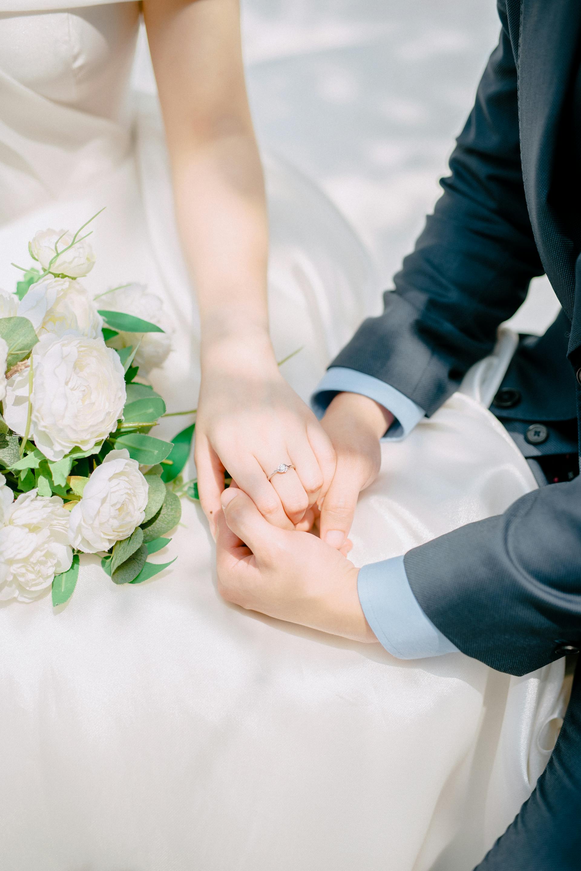 Un primer plano de unos recién casados tomados de la mano | Fuente: Pexels