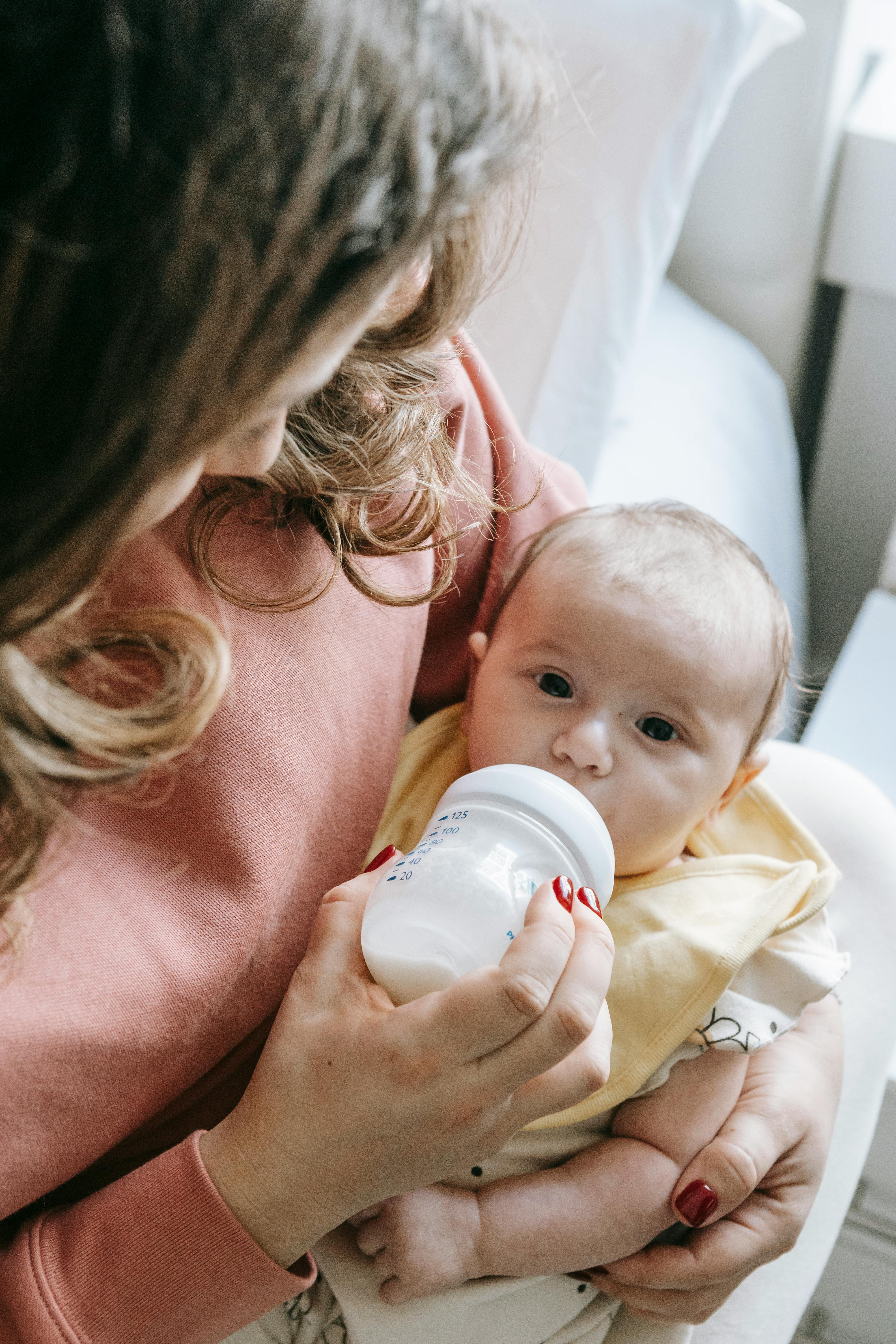 Una mujer alimentando a un bebé | Fuente: Midjourney