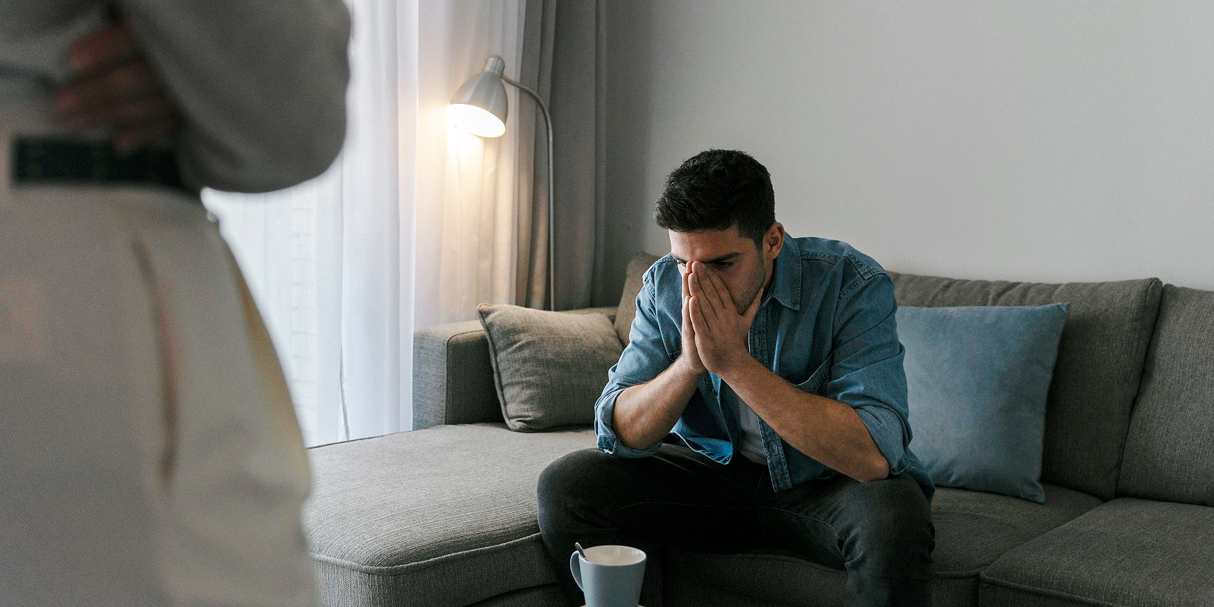 Un hombre sentado en un sofá con las manos en la cara | Fuente: Freepik
