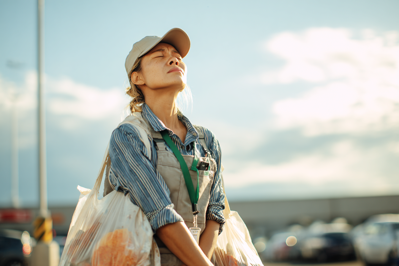 Una mujer en un estacionamiento llevando bolsas de las compras | Fuente: Midjourney