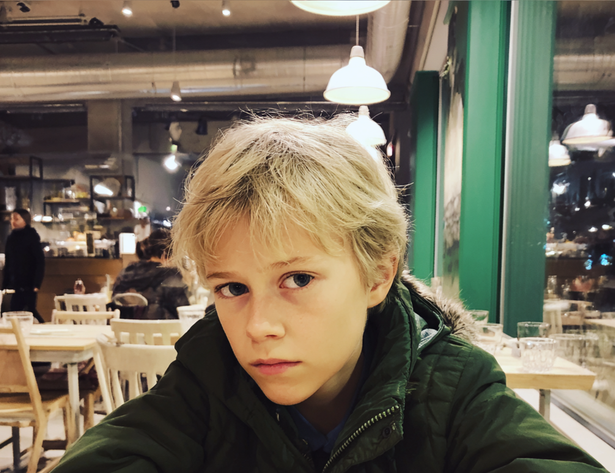 Primer plano de un niño sentado a la mesa | Fuente: Midjourney