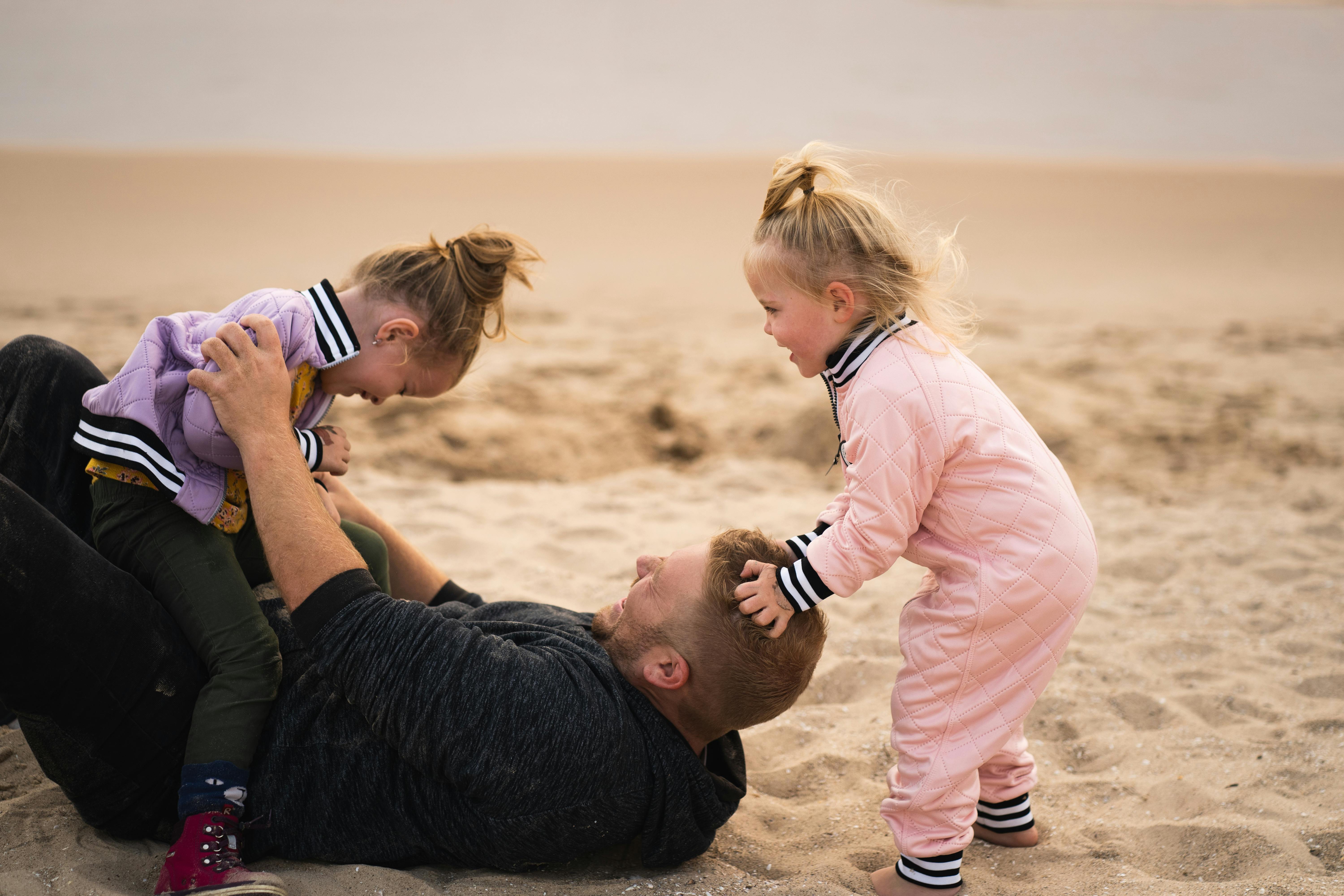Un padre jugando con sus hijos | Fuente: Pexels