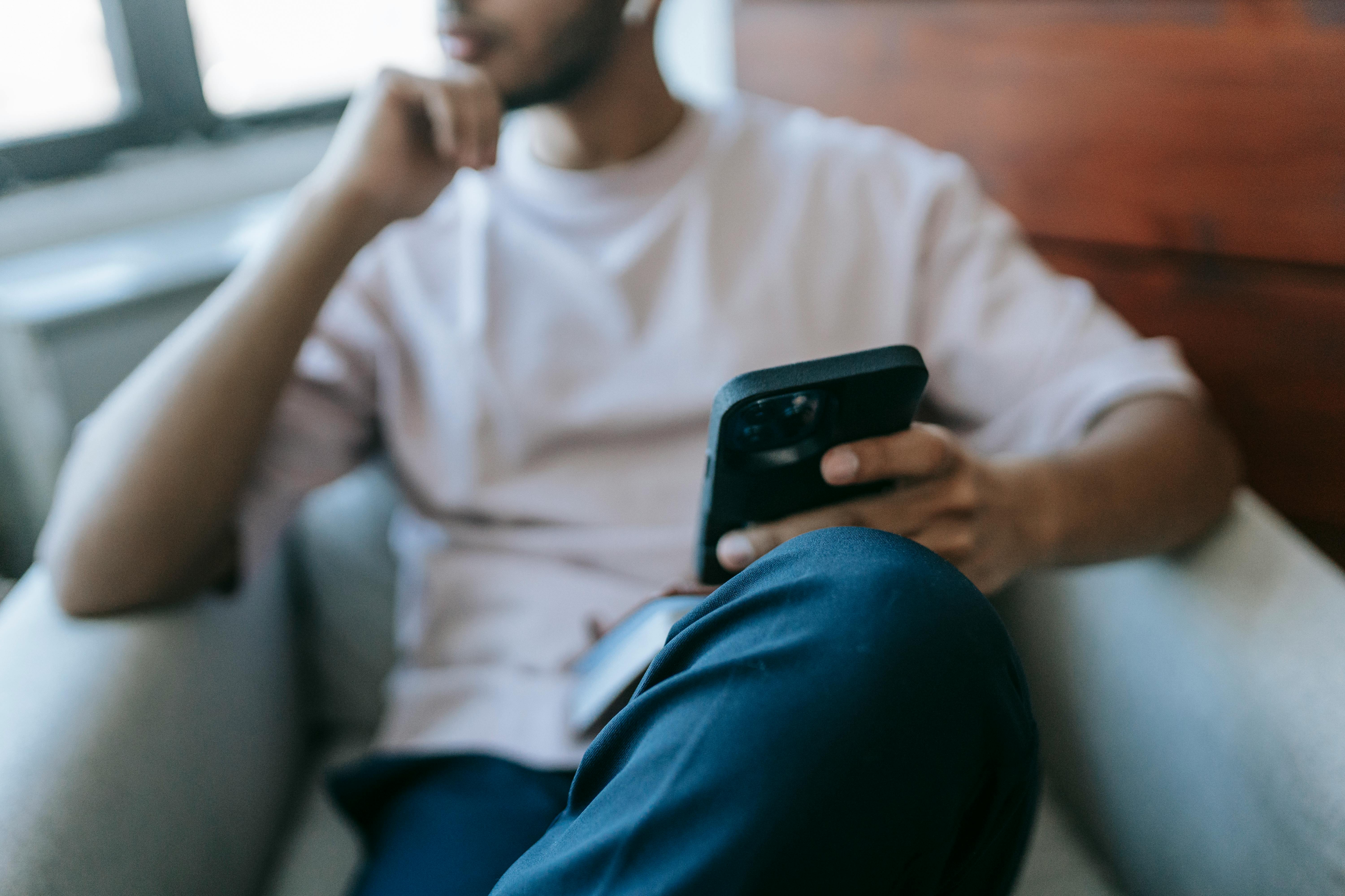 Un hombre pensativo sostiene su teléfono | Fuente: Pexels