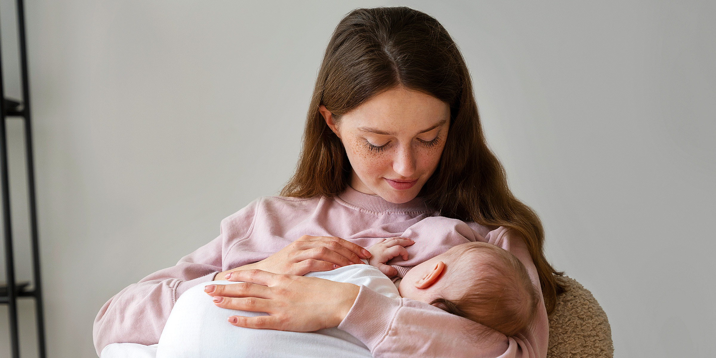 Una mujer joven alimentando a su bebé | Fuente: Freepik