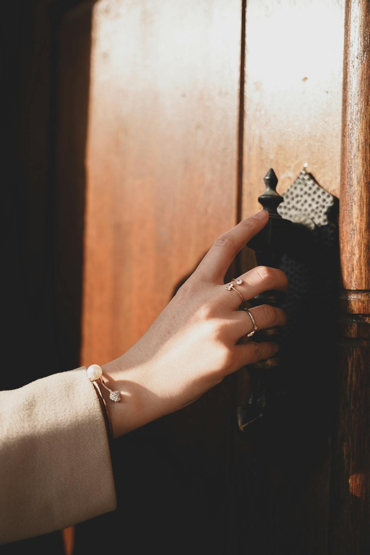 Una mujer sujetando la manilla de una puerta | Fuente: Pexels