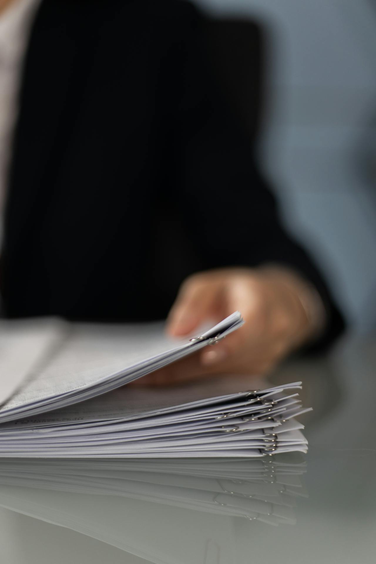 Una persona sujetando papeles | Fuente: Pexels