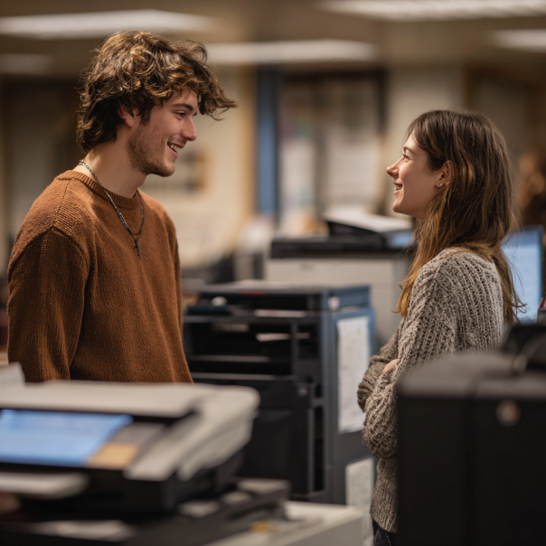 Un hombre y una mujer charlando en la biblioteca | Fuente: Midjourney