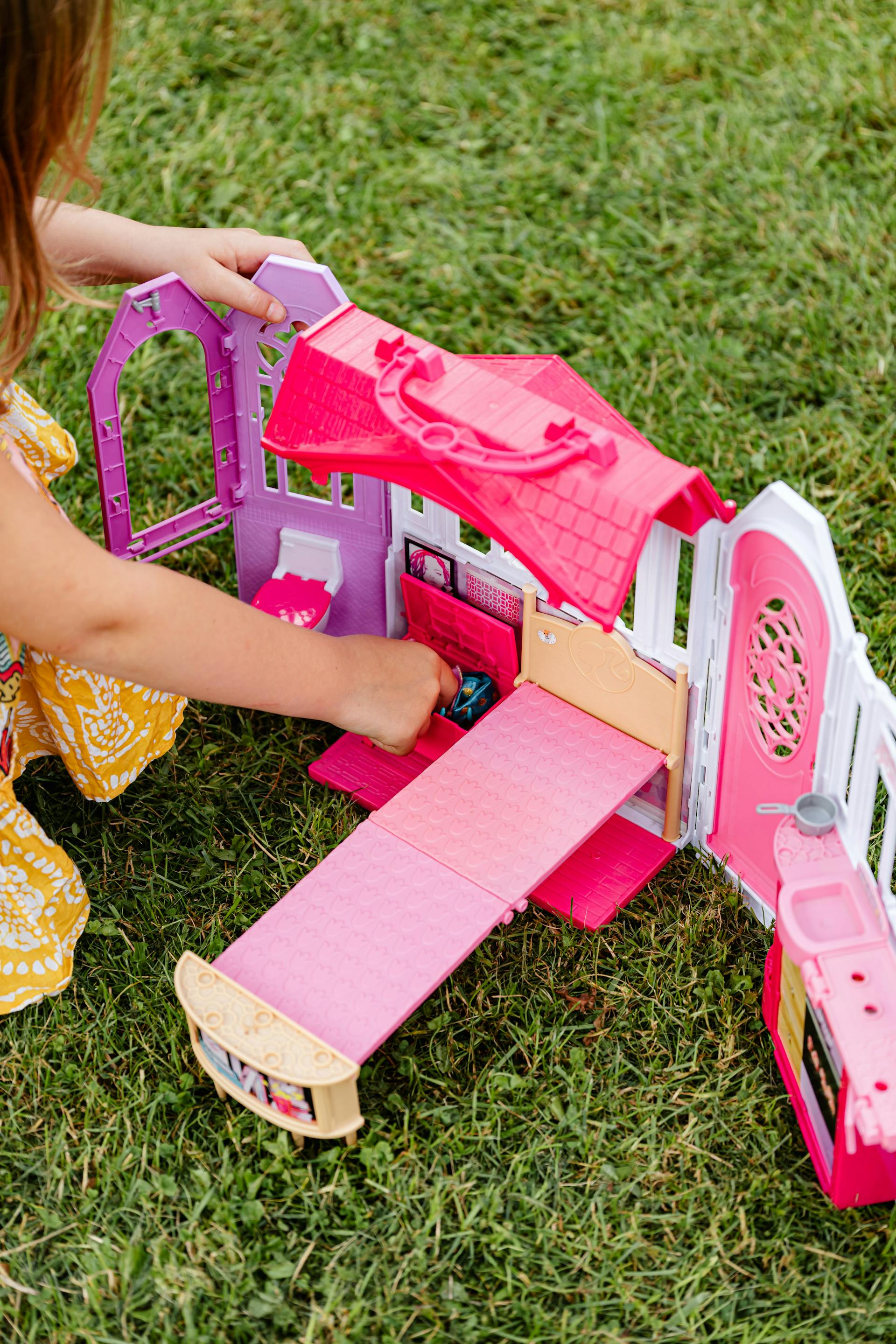 Una niña jugando con una casa de juguete | Fuente: Pexels