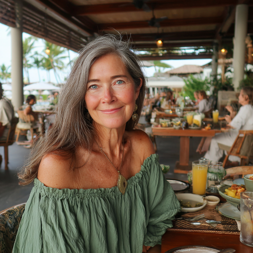 Una mujer mayor sonriente sentada a una mesa | Fuente: Midjourney