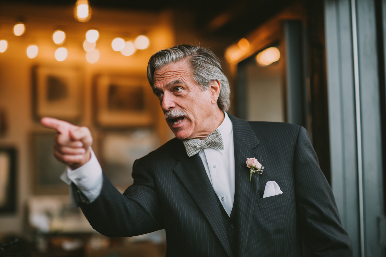 Un hombre hablando severamente durante un banquete de boda | Fuente: Midjourney