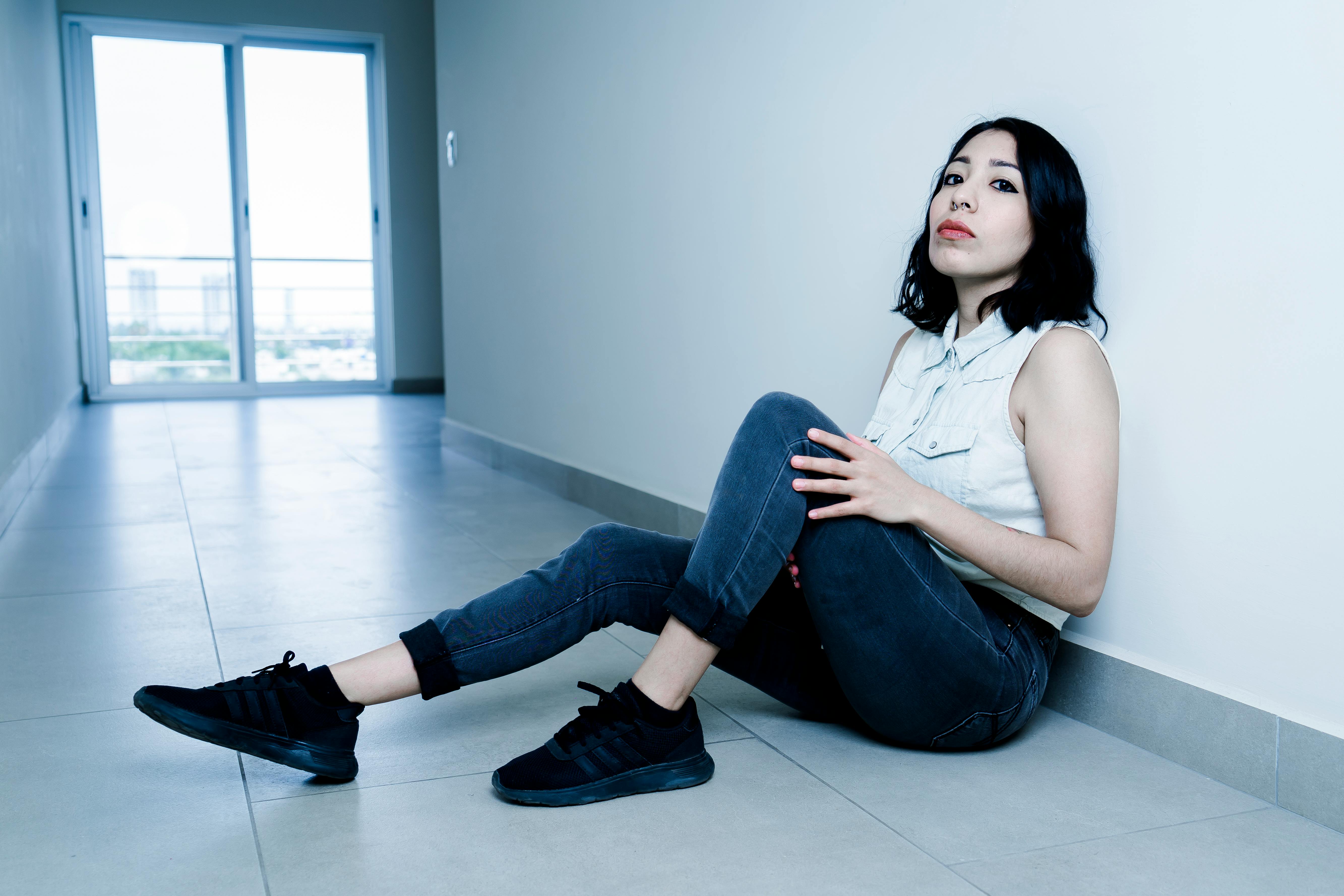 Una mujer sentada en el suelo | Fuente: Pexels