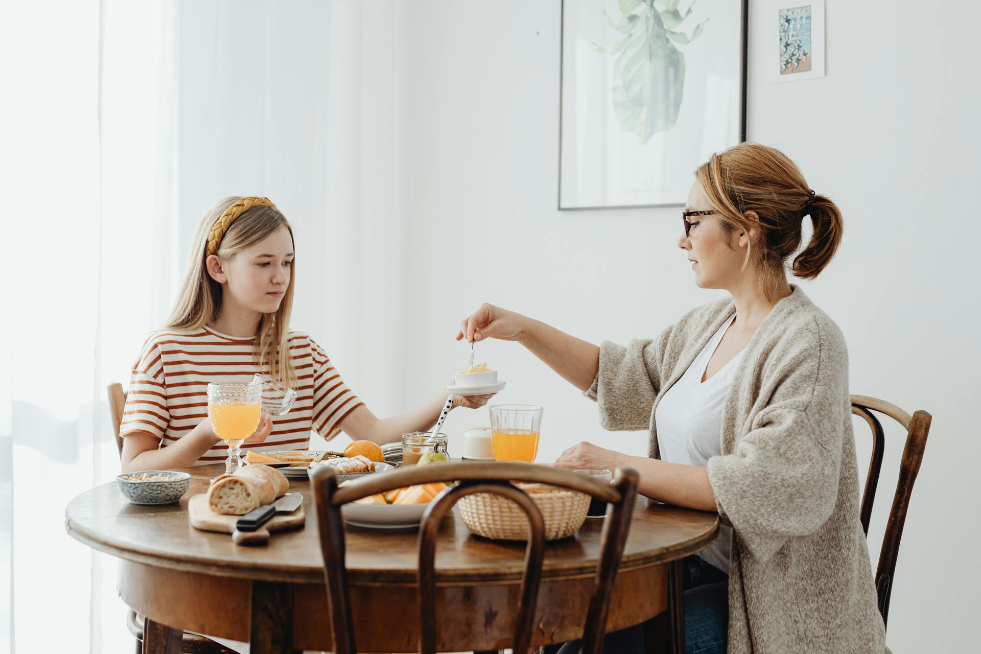 Una mujer y una adolescente sentadas a la mesa del comedor | Fuente: Pexels
