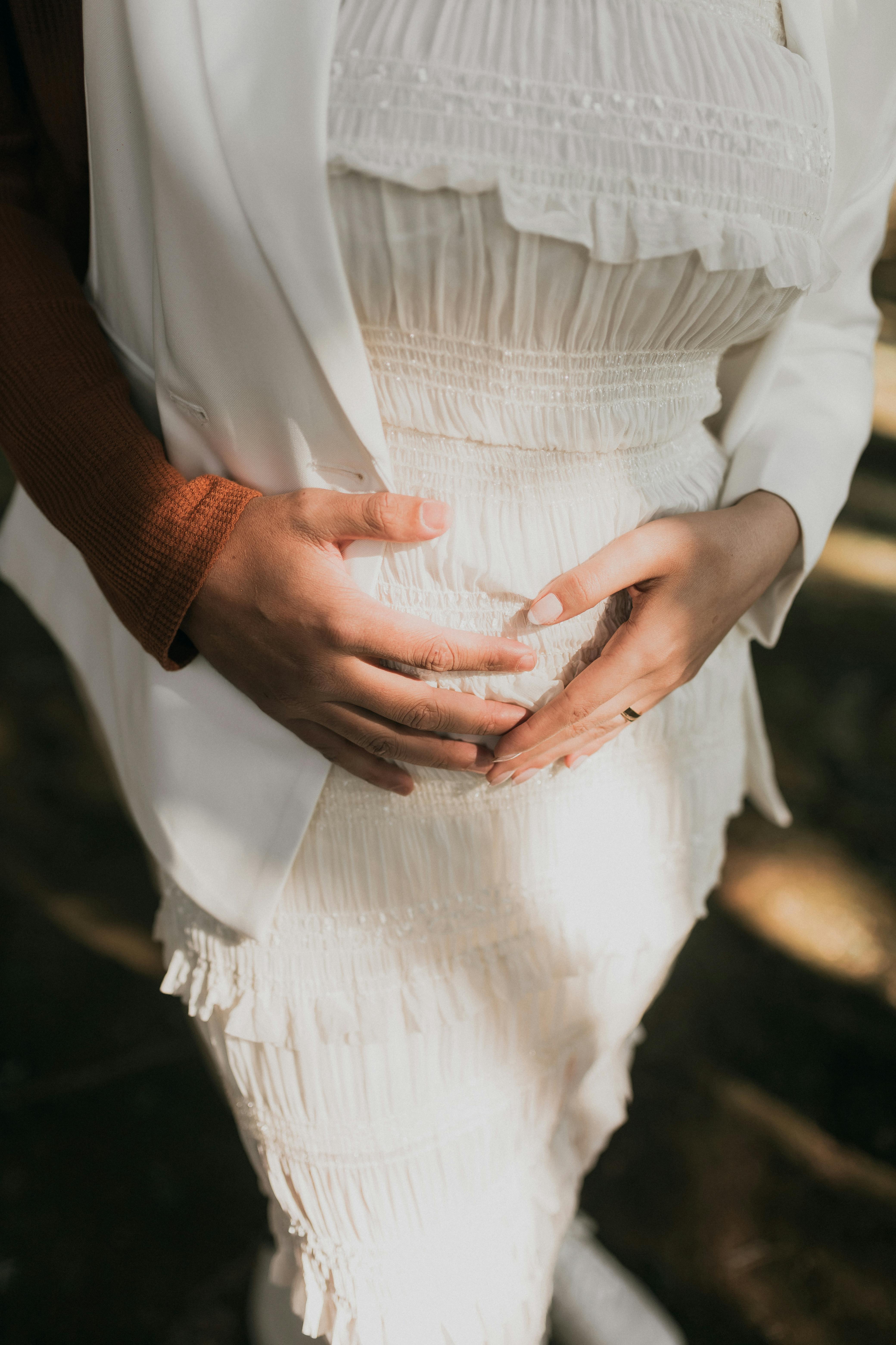 Una pareja tocando una barriga de embarazada | Fuente: Pexels